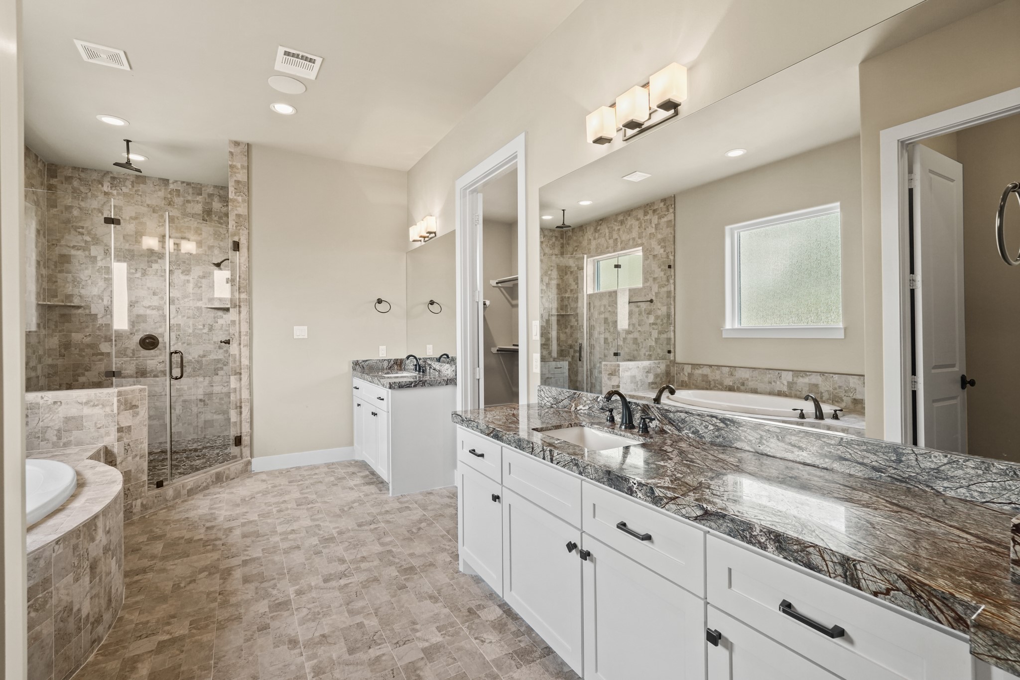 Enchanting ensuite master bathroom features tile and granite countertops throughout.
