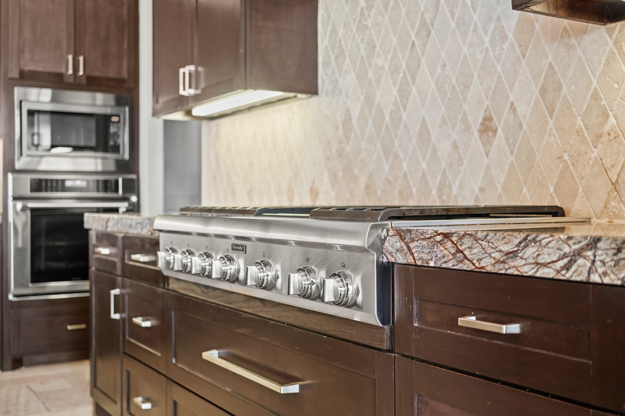The kitchen is well appointed with Jenn-Air and Thermador appliances.