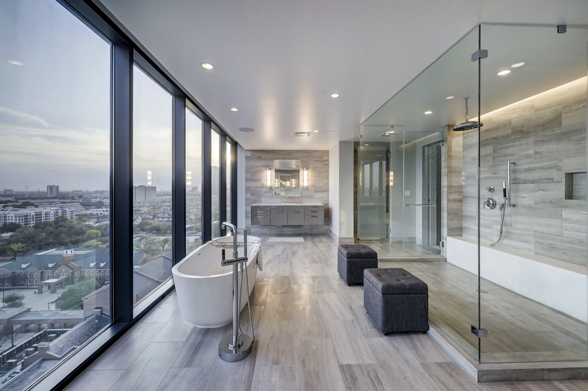 The primary bath is simply gorgeous. Highlights include tile floors, dual Poggenpohl vanities with silestone counters, dual private commode areas, an oversized frameless shower and a freestanding tub with incredible exterior views.