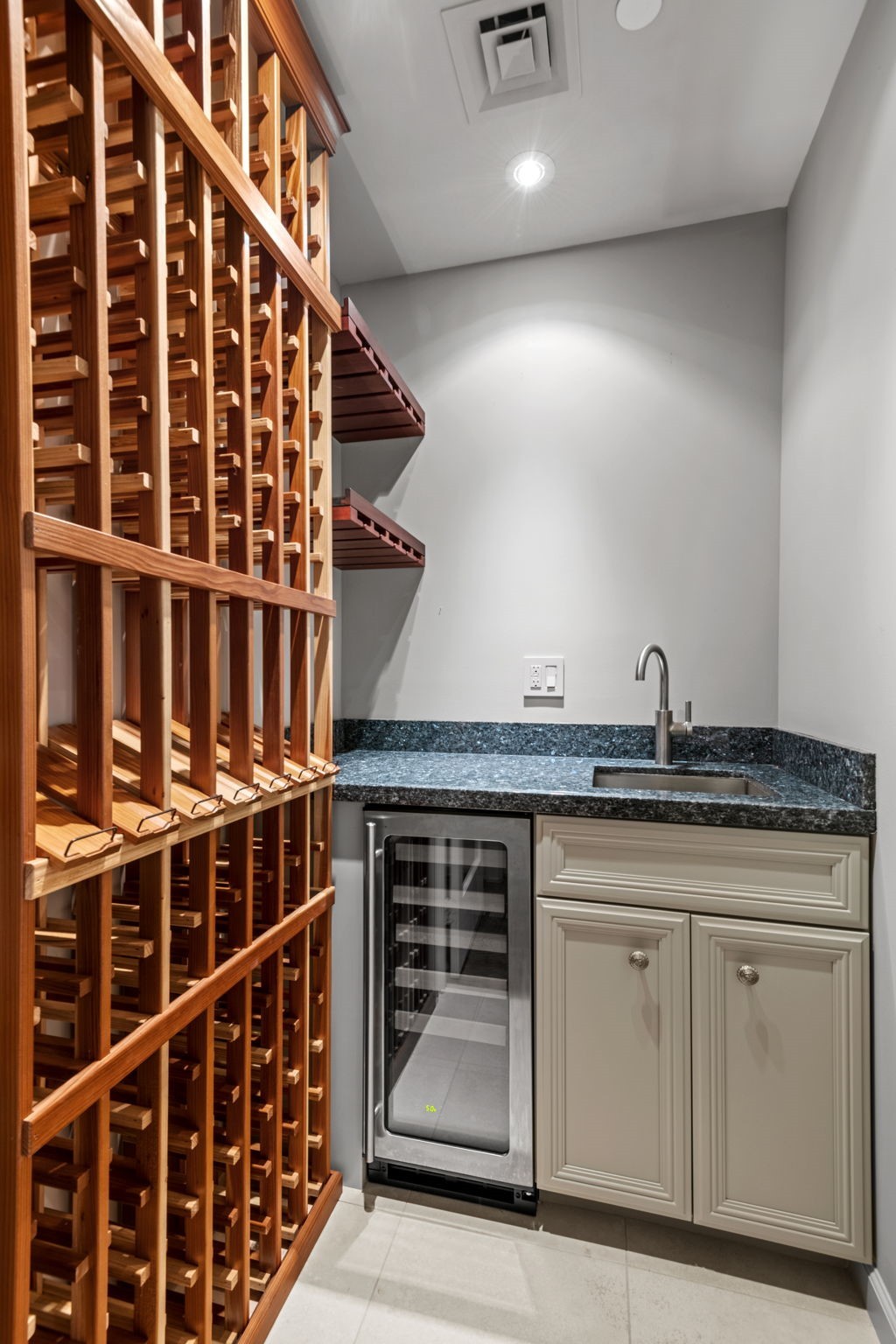 5x4 Wine Room - 
Storage is available for 126 bottles. Wine refrigerator and glass racks are also part of the package. Sink is set in a granite counter. All is ready for your next gathering.