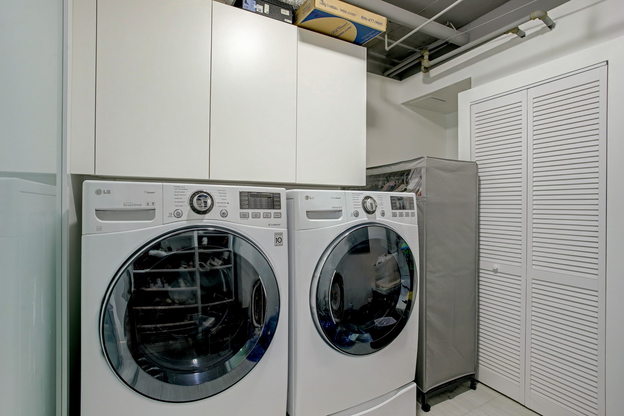 Large utility room with full size washer/dryer and tons of extra storage.