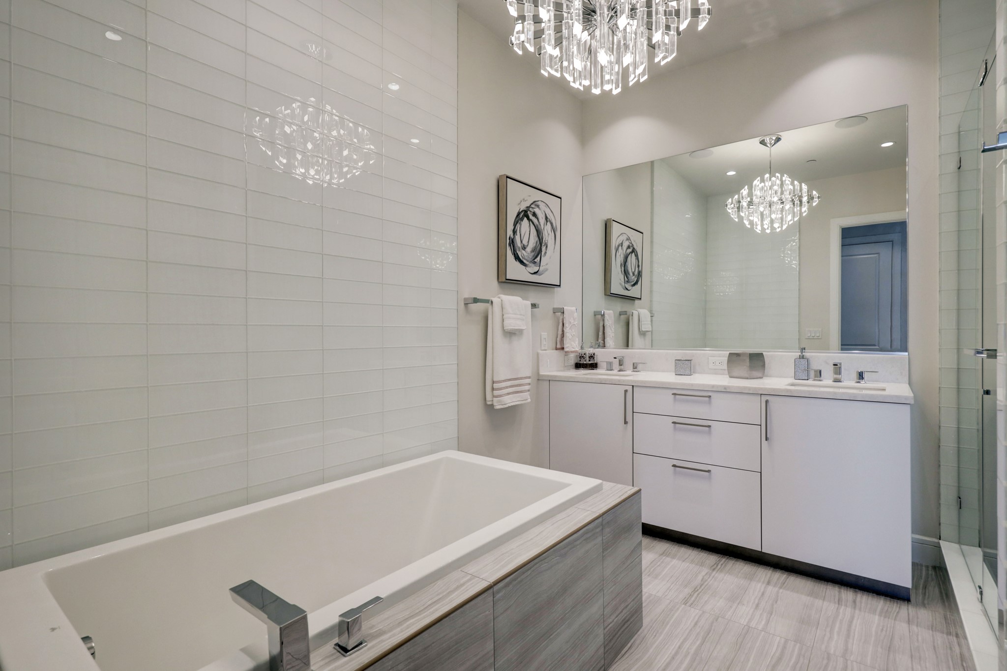 Primary Bathroom features tile floors, double vanity, large seamless glass shower and separate soaking tub.