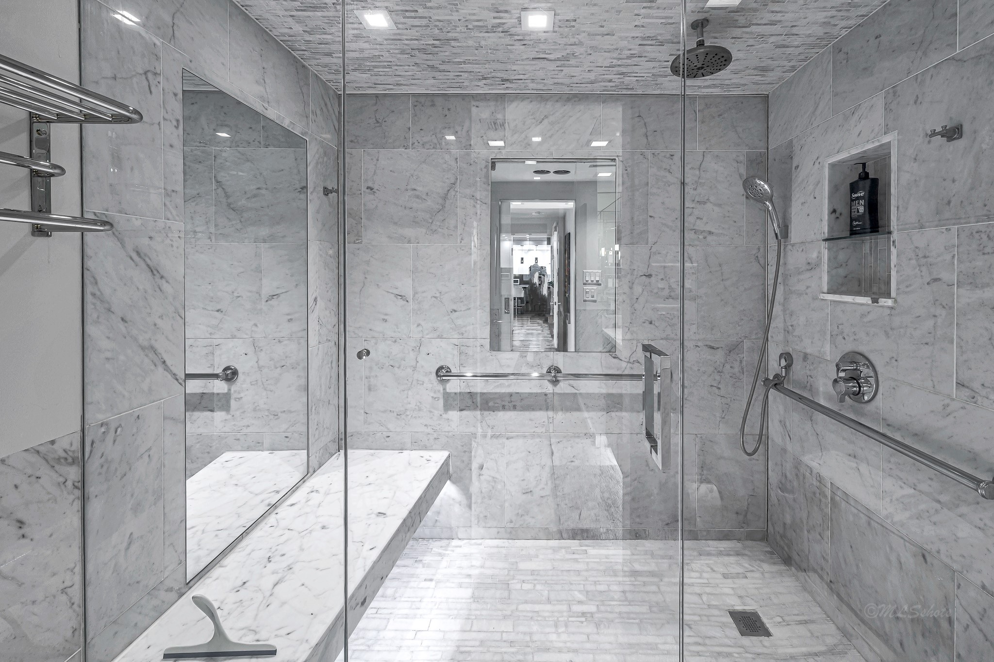 Huge walk-in shower with rainwater feature, handheld shower attachment, mirrors,  recessed shampoo niche, bench and recessed lighting