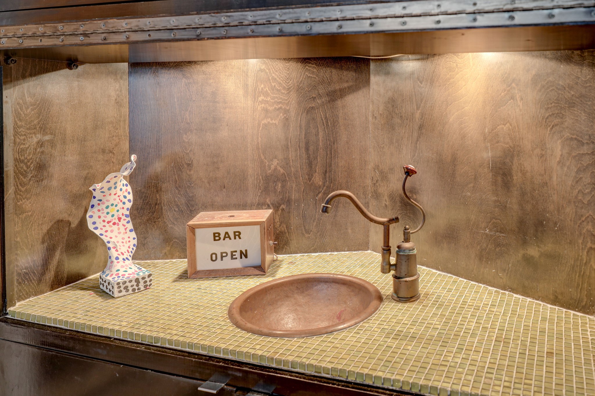 Wet bar with vintage copper bar sink and faucet.