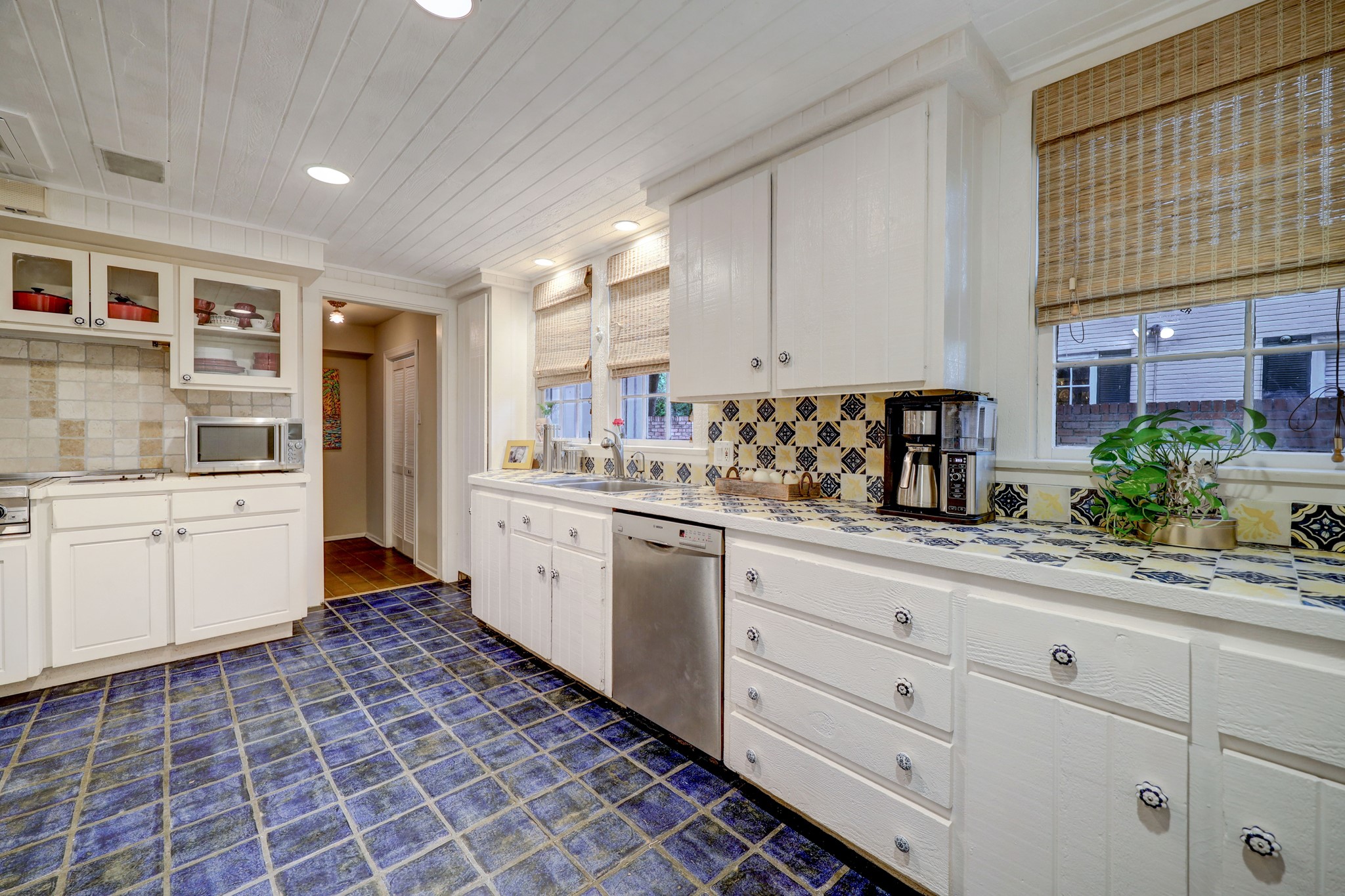 Kitchen with tile floor and ship lap ceiling, vintage Mexican tile on the countertop and backsplash.