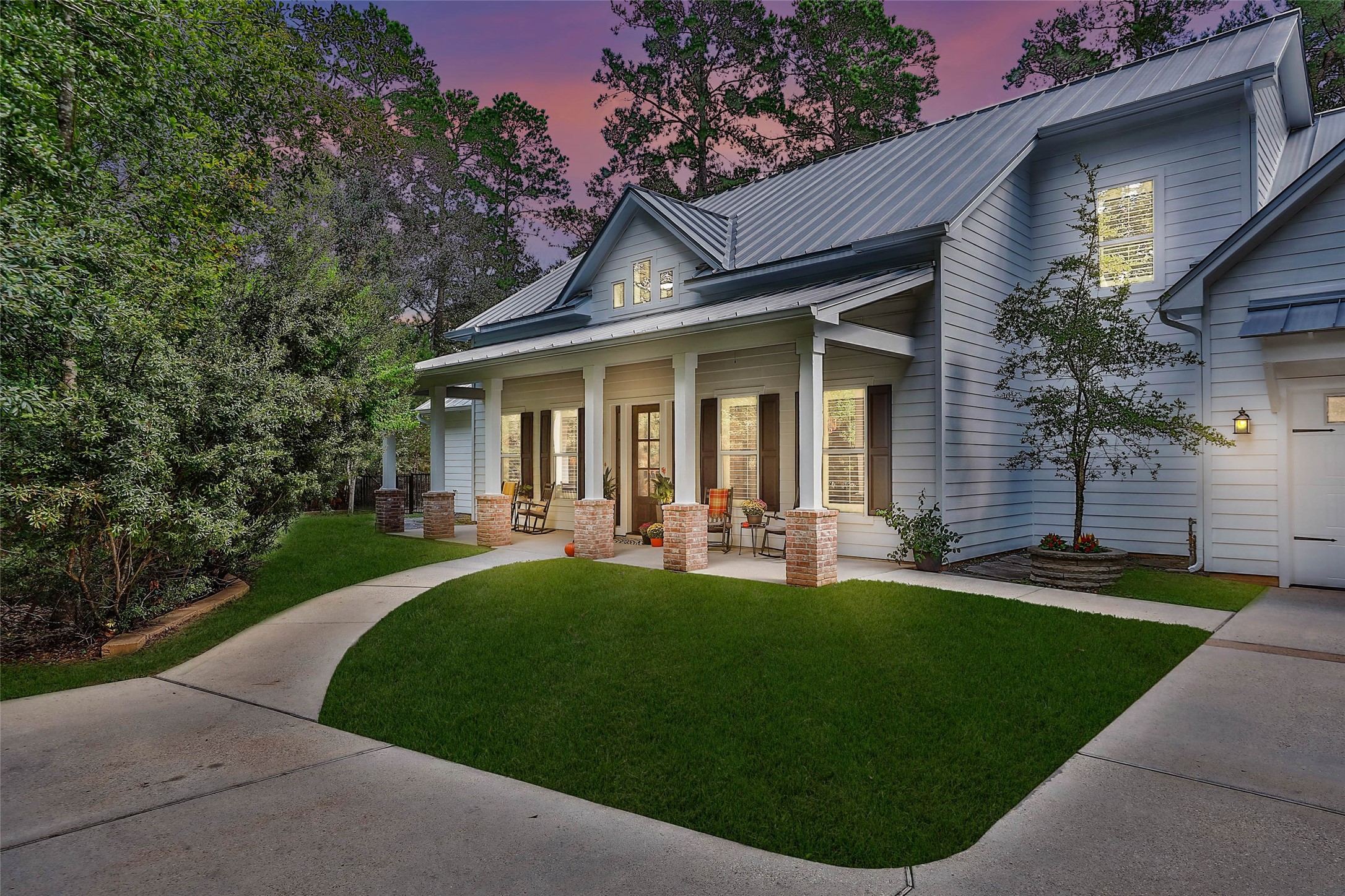 Twilight view of this Modern Farmhouse nestled on 2.023 Lakefront, Wooded acres in Magnolia, Texas...
