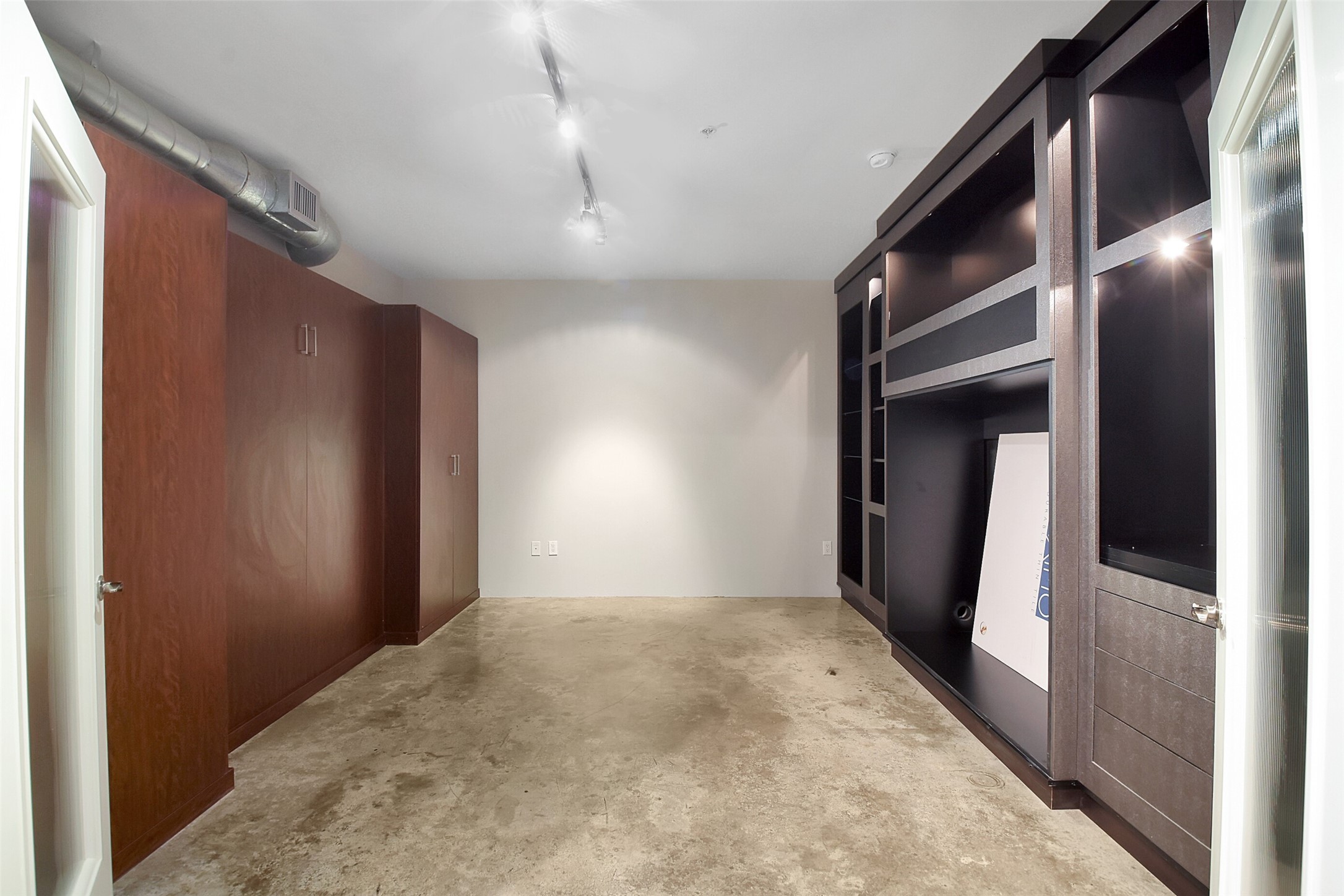 THIS SECONDARY BEDROOM IS LOCATED ON THE 1ST FLOOR AND INCLUDES A PULL DOWN MURPHY BED FLANKED BY CLOSETS.