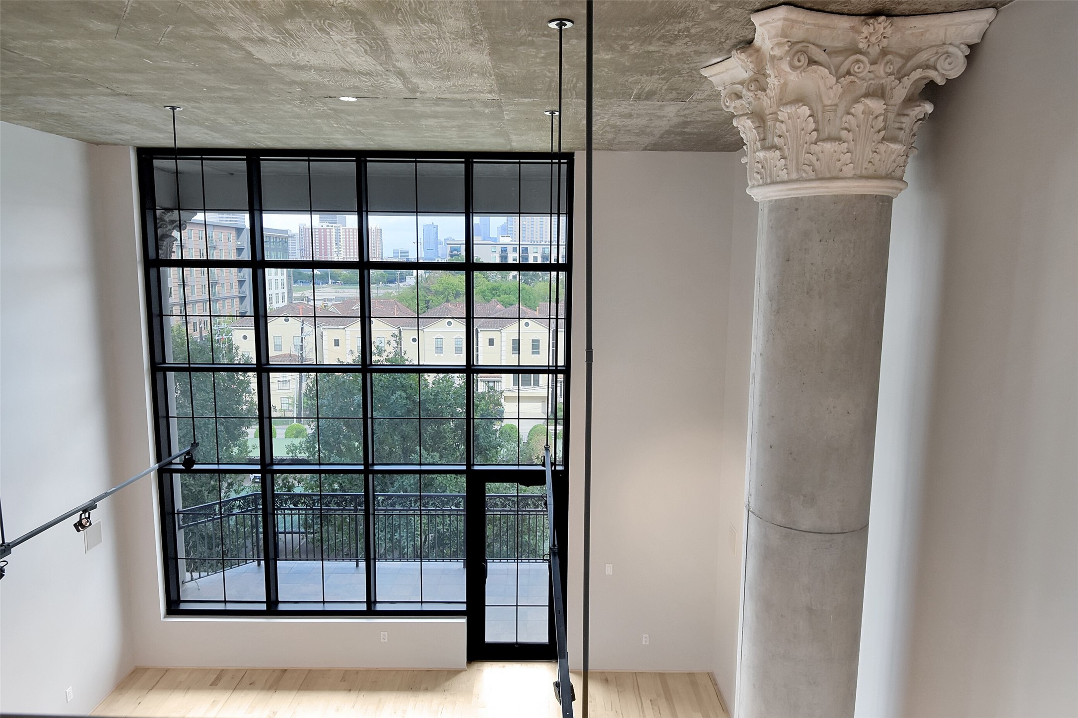 VIEWS OF THE MAIN LIVING AREA WITH IMPOSING ARCHITECTURAL PILLAR AND SPECTACULAR VIEWS OF DOWNTOWN HOUSTON.