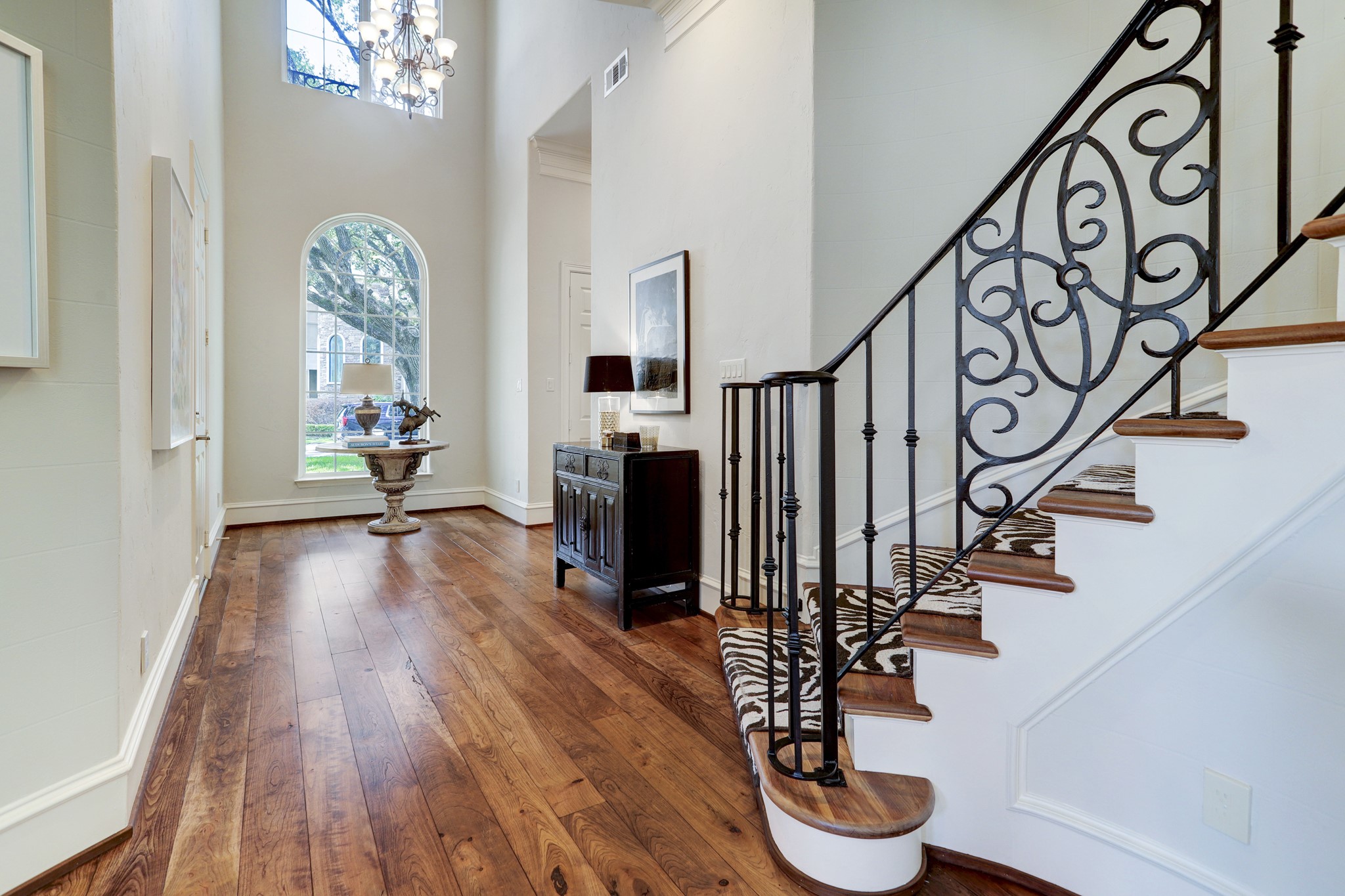 Another view of the beautiful designed metal raining staircase and hardwood flooring.
