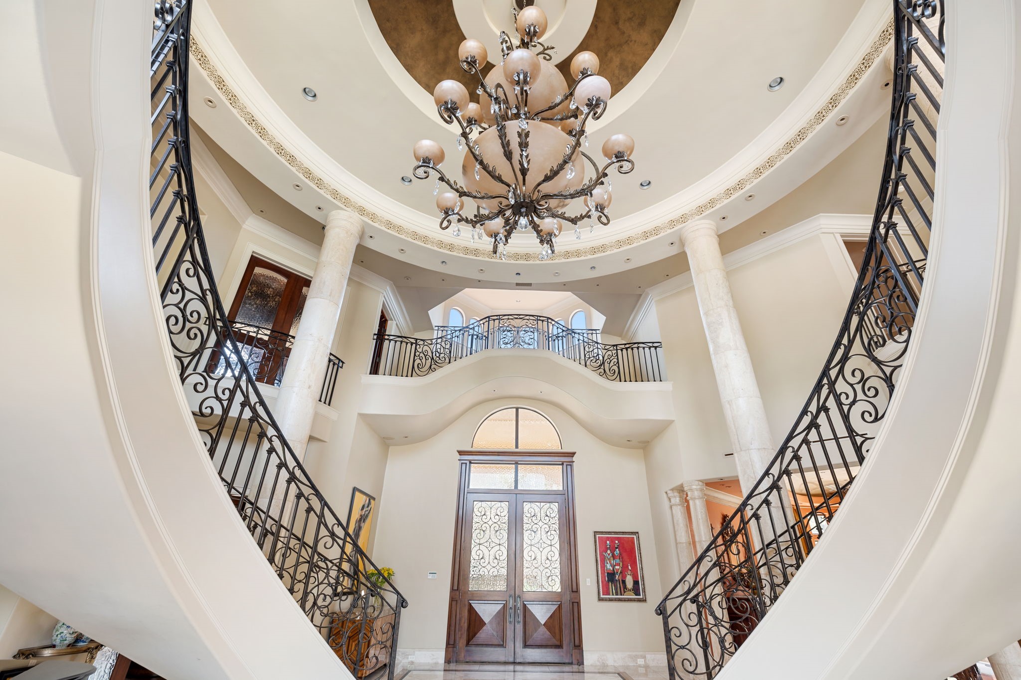 Every aspect of this estate is grand. Mahogany French doors open to the Sala d'Ingresso--the Grand Foyer featuring duple Iron & Teardrop Crystal Chandelier in a richly fauxed niiche with the Indoor Sky Bridge at the center.