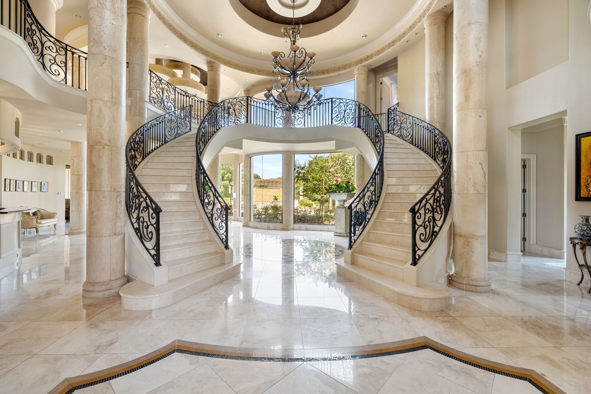 Forming the heart of the home, the Grand Foyer is palatial in scale with a captivating double marble clad helical staircase, Baroque round stone columns, and Marble floors with decorative inlays. The light within is boundless.