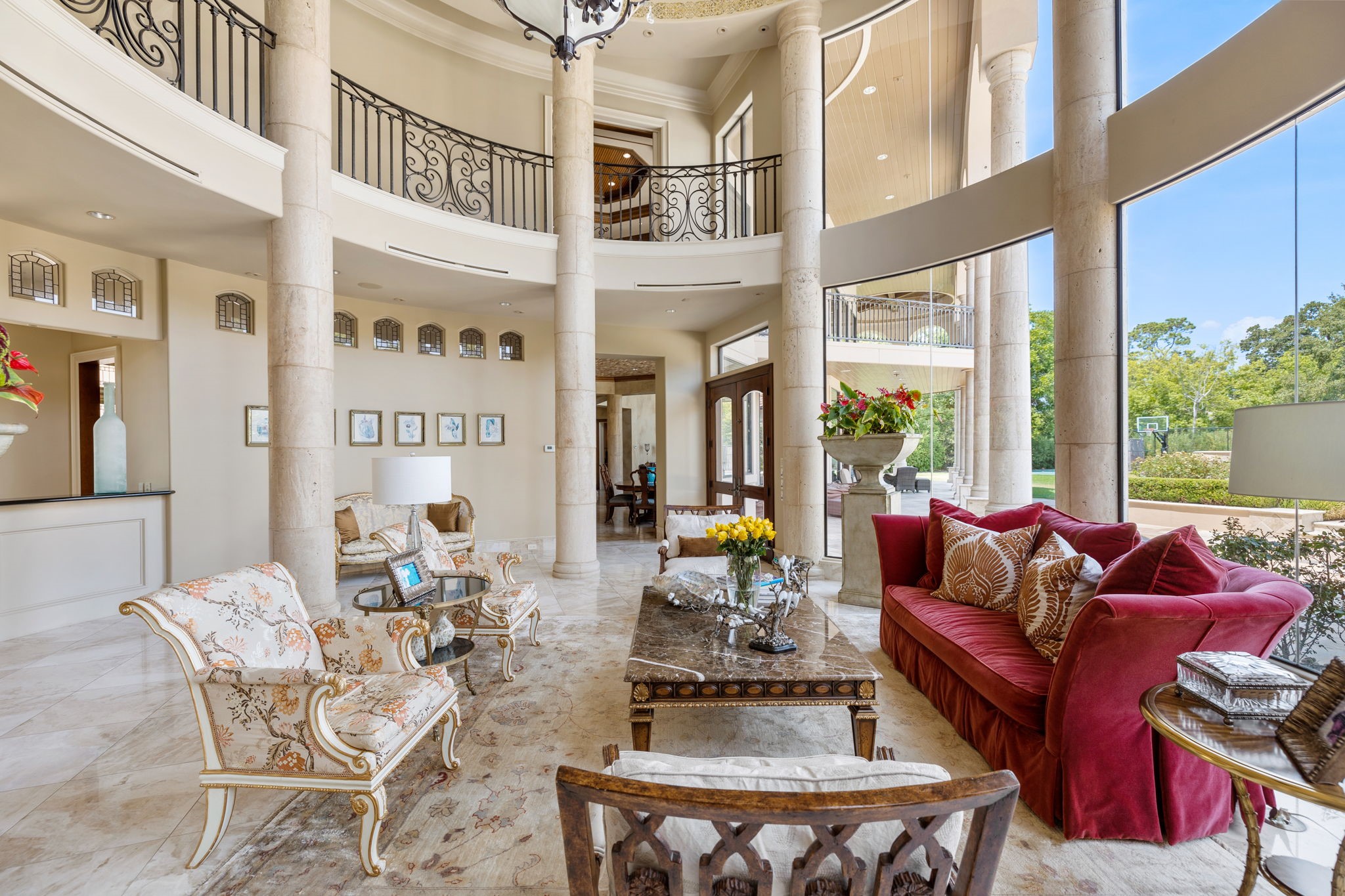 Within the Rotunda is the formal Living Room adorned with Baroque round stone columns, arched miniature leaded glass transom windows, and soaring double height butted glass windows with clear views of the clear Texas skies!
