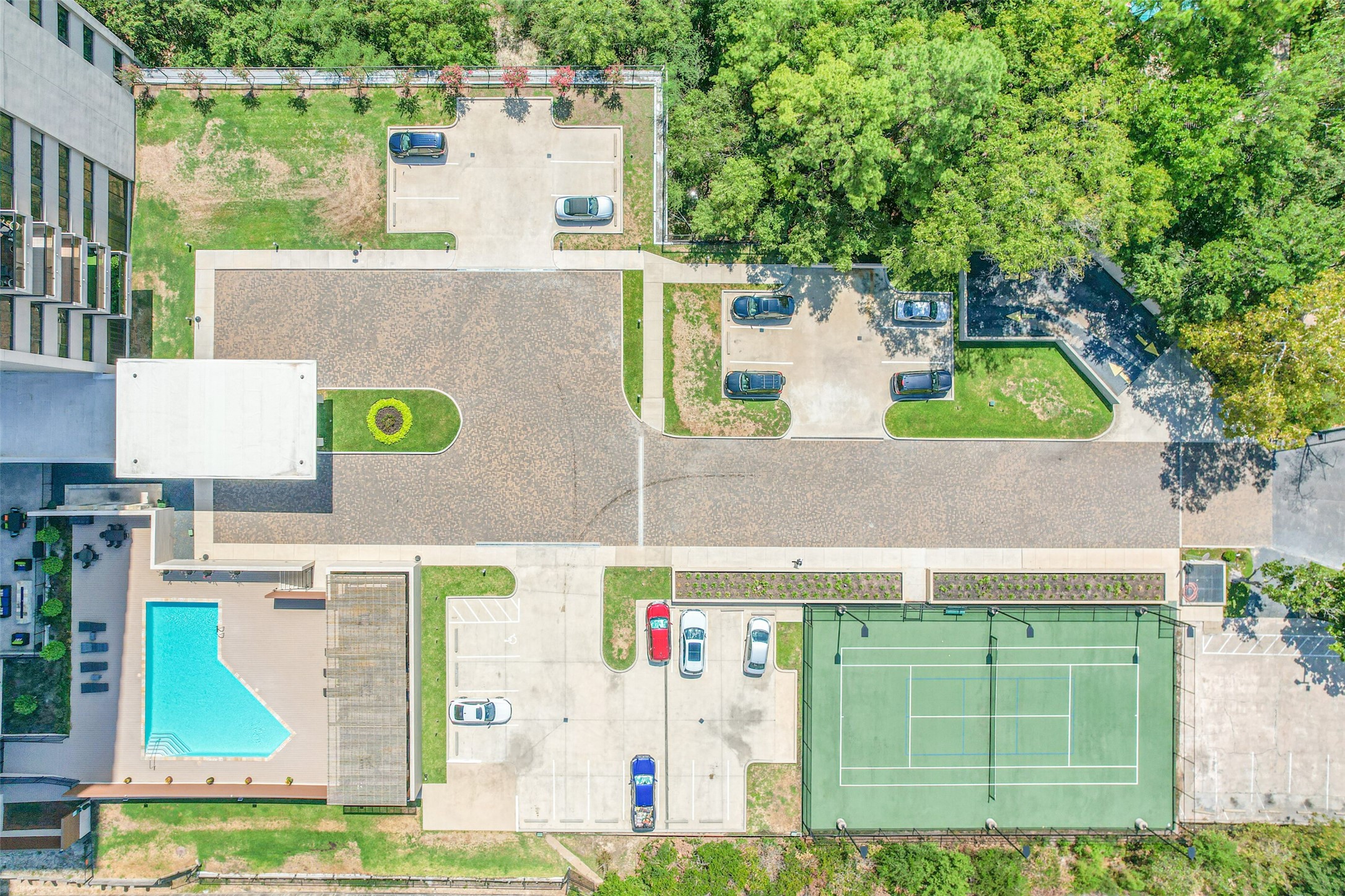 Aerial view of the spacious grounds, pool, visitor parking and tennis/pickle ball court.