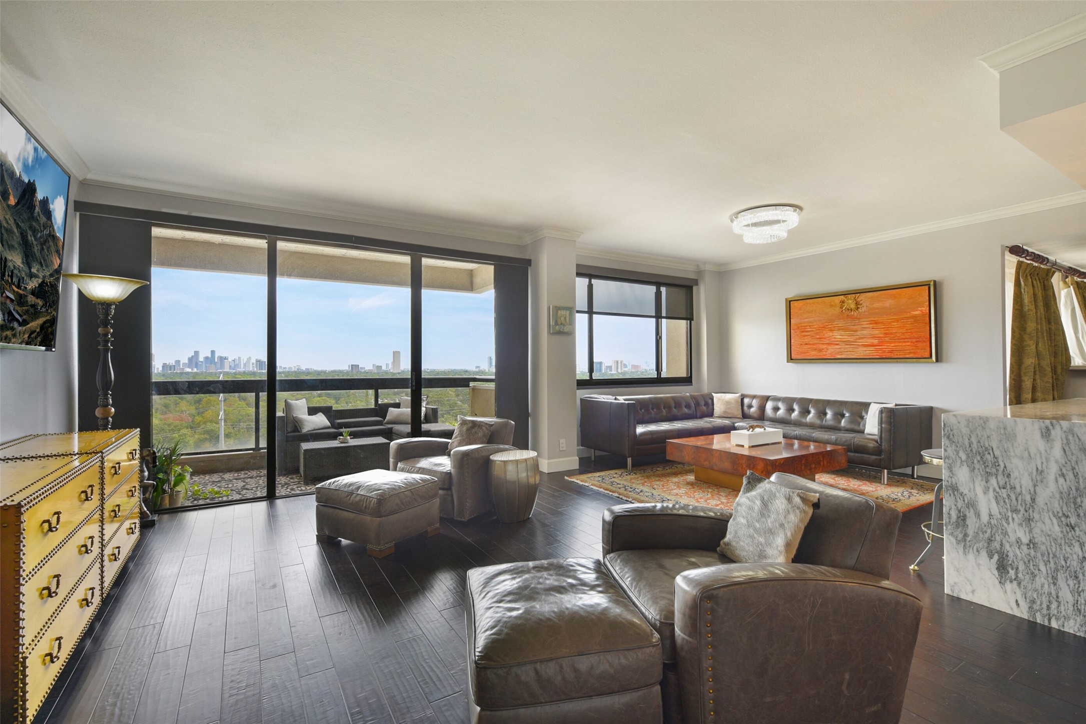 Step into the living area, adorned with rich wood floors and floor-to-ceiling windows that frame breathtaking views.