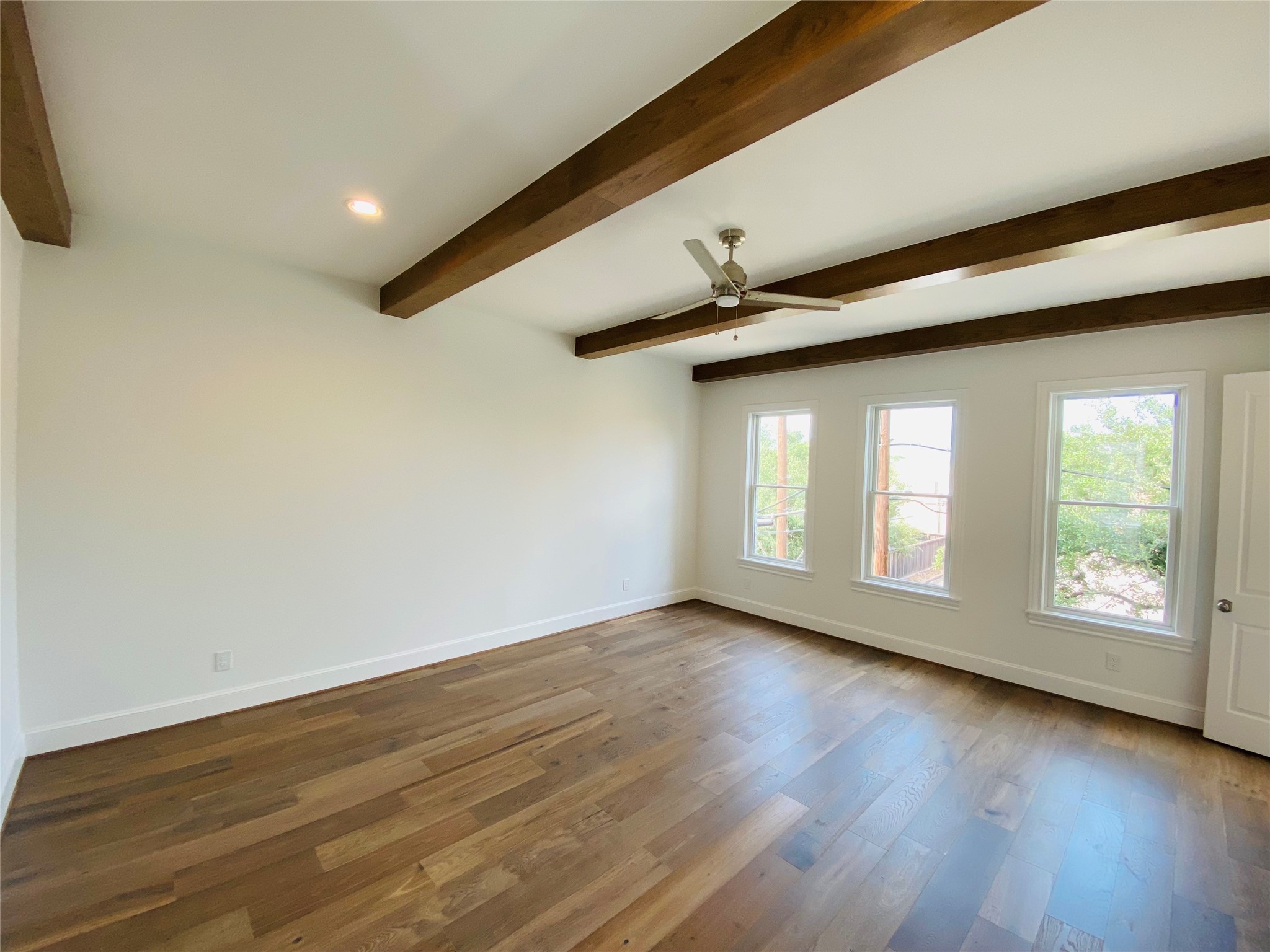 Primary bedroom with beautiful beams and wood floors.