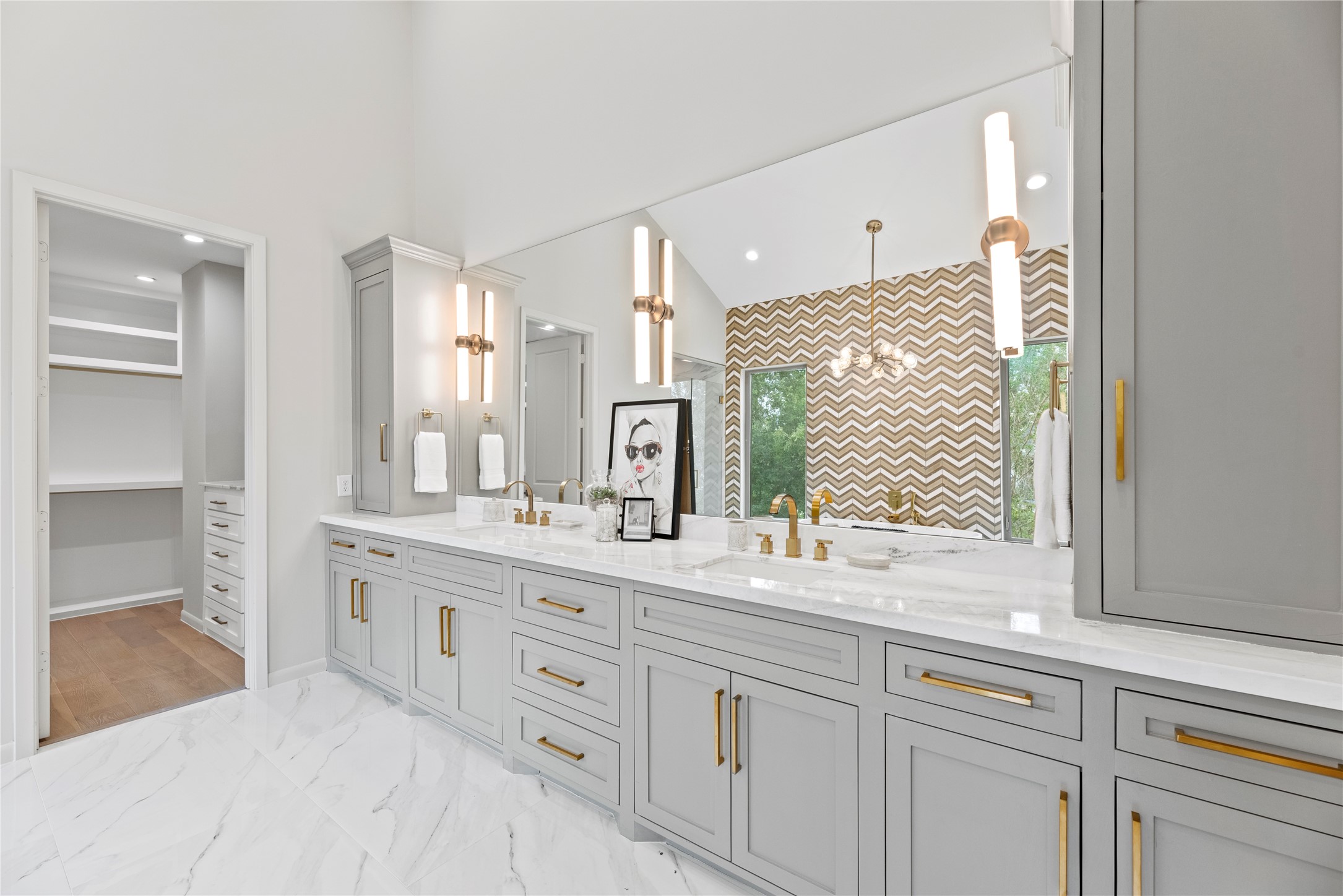 The 3rd floor PRIMARY BATH (approx 13.5X13.6) features quartz counter, custom cabinets, brushed bass fixtures, custom sconces & lighting, two sinks, two walk-in closets (only one shown), a separate shower and tub.