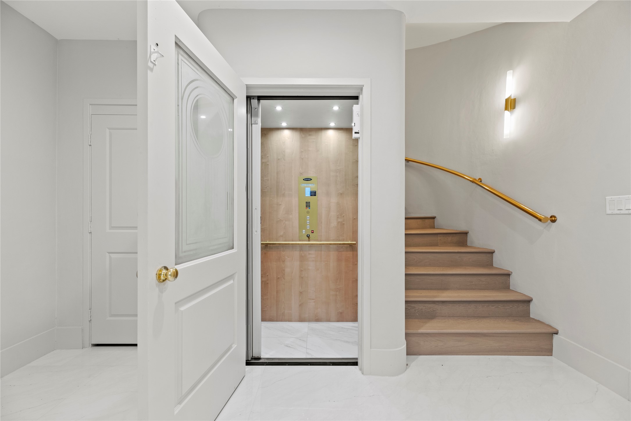 This close up of the 2021 elevator goes to all three floors- use it for groceries, holiday decorations, entertaining, health challenges & more! Note the brass railing on the stairs.