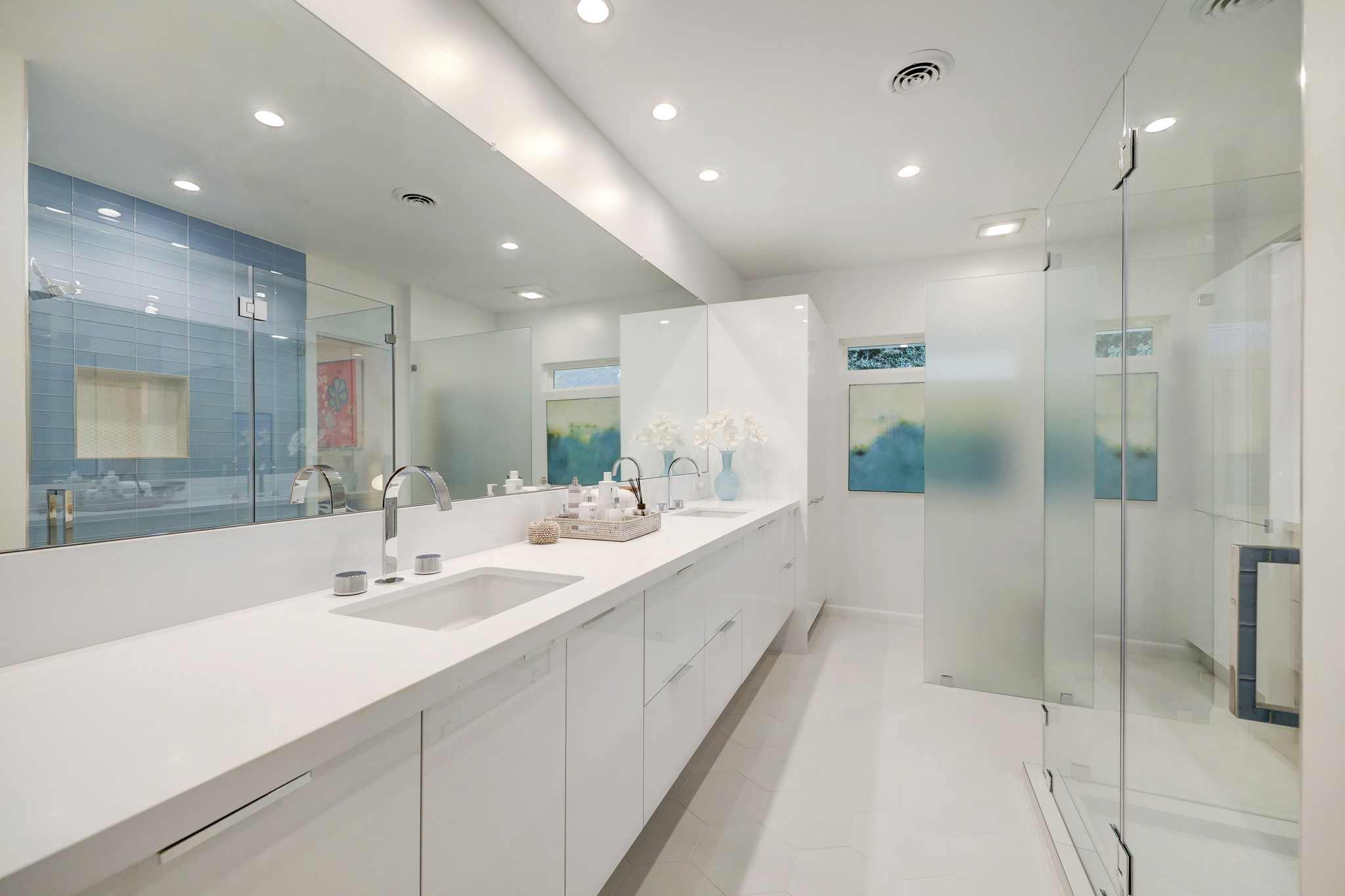En-suite secondary bath features double sinks and walk-in shower with colorful accents.