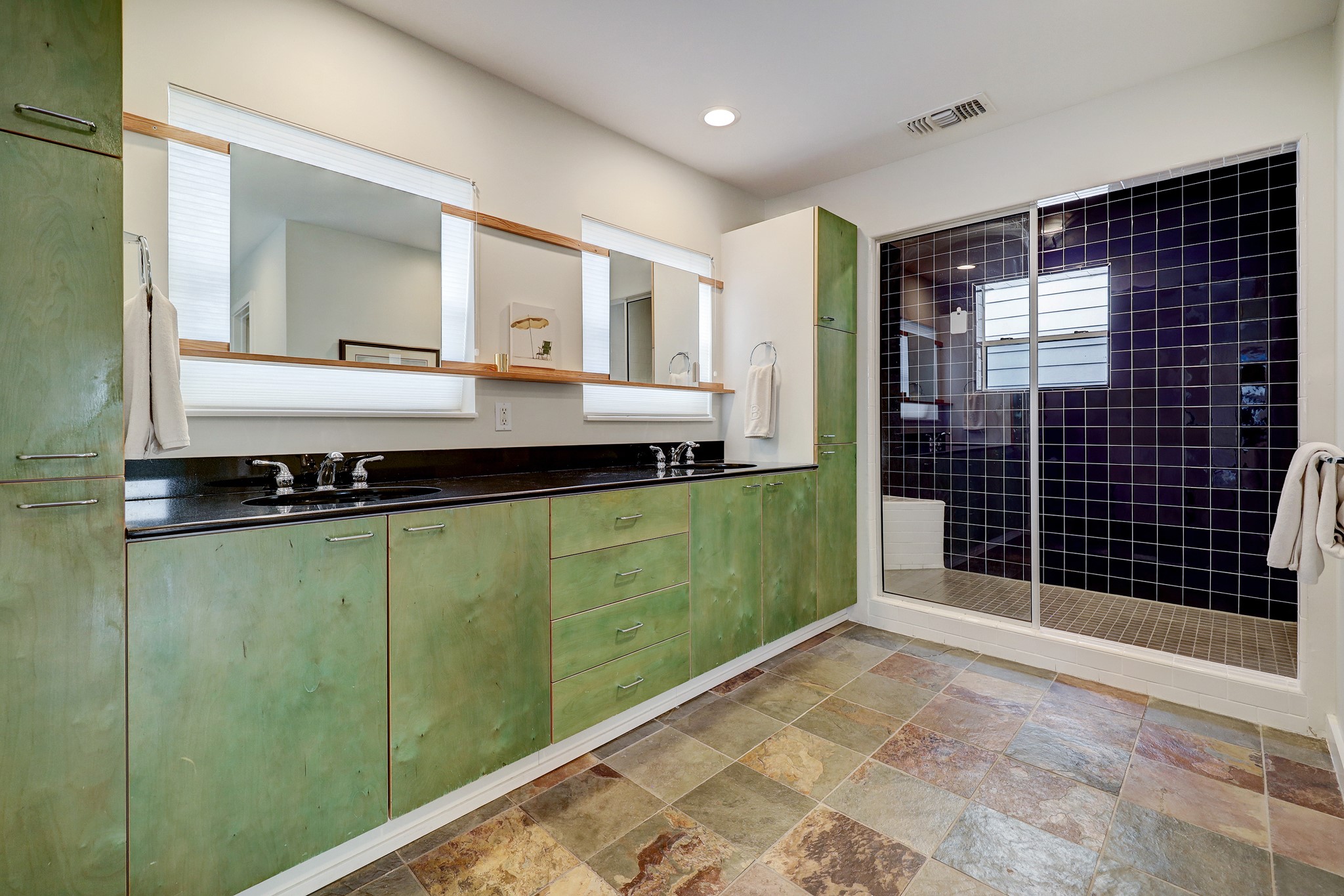 Double sinks, amazing storage, and an oversized shower make this primary bathroom both functional and eye-catching.