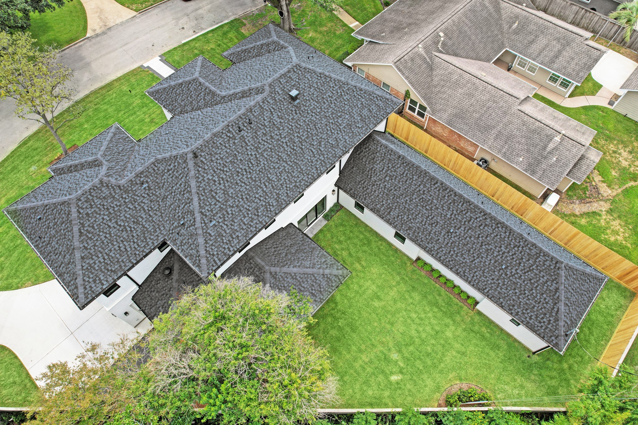 Aerial view of home and backyard.  Architectural high-profile roof shingles are thicker and more durable providing a higher wind rating than typical 3-tab shingles.