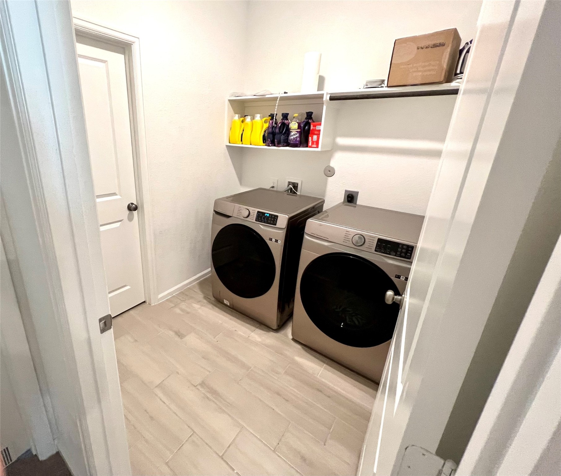 Oversized laundry room has additional storage closet attached.