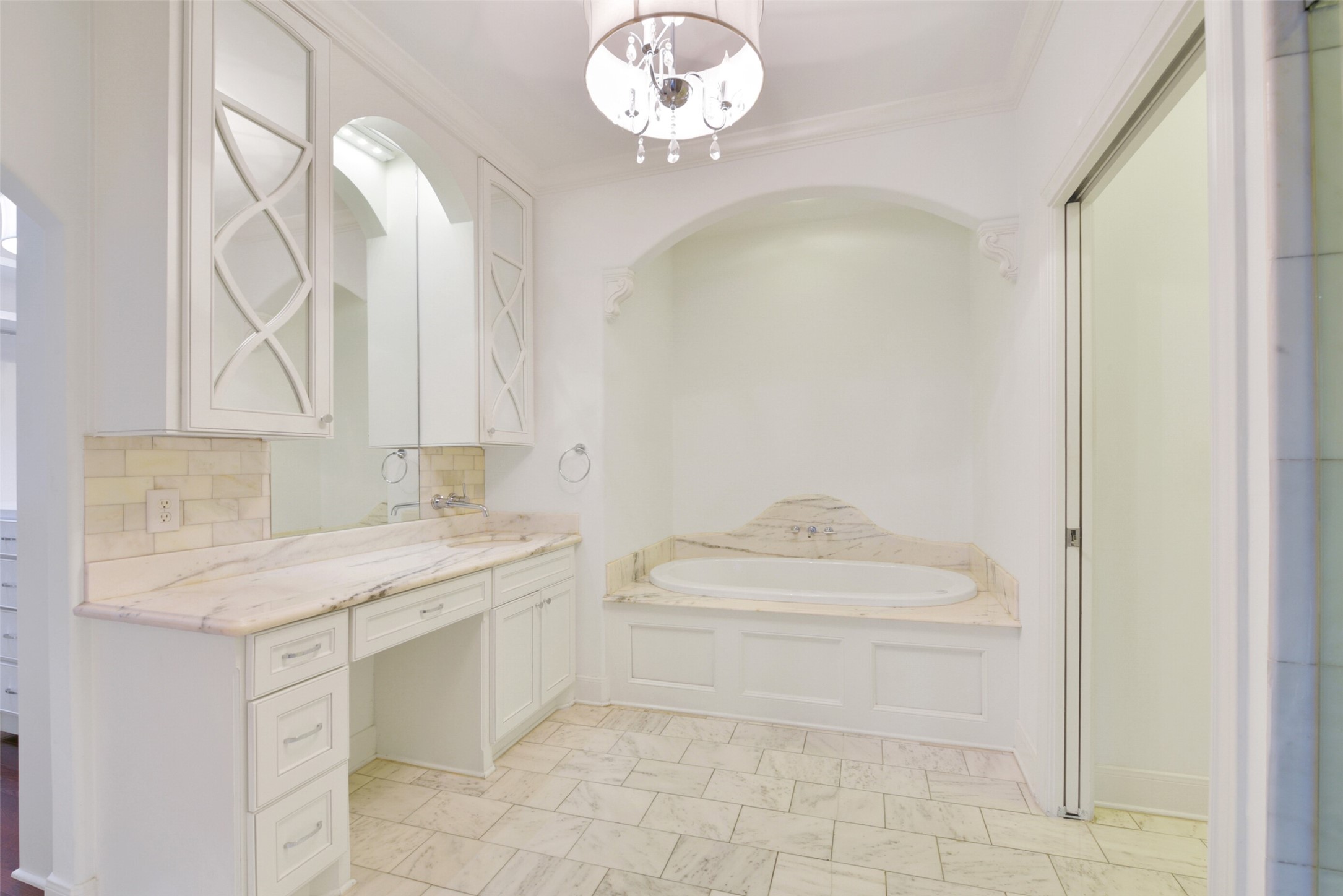 One of the dual primary bath's includes sit down vanity, large soaking tub, marble floors, countertops and surrounds as well as a separate shower.