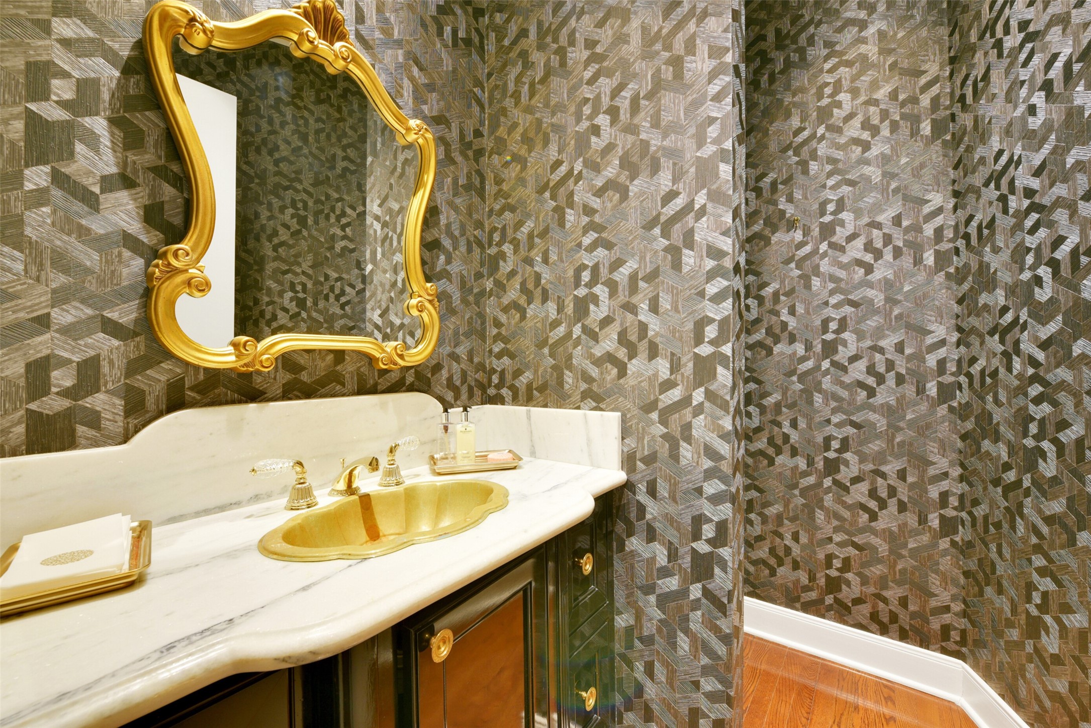 Elegantly appointed with designers finishes, the powder room is located off the entry foyer.
