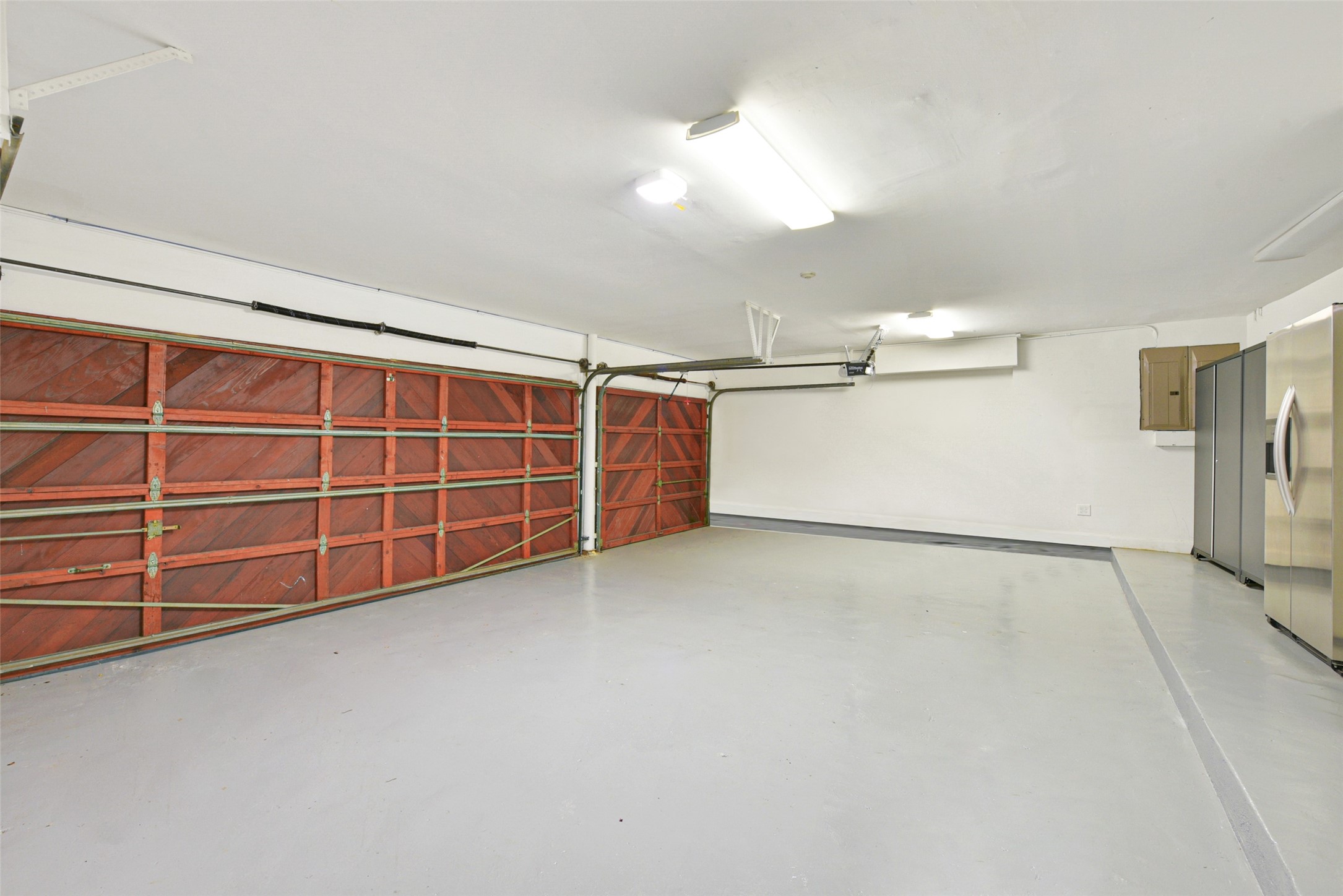A view inside the three car garage featuring two large storage closets.