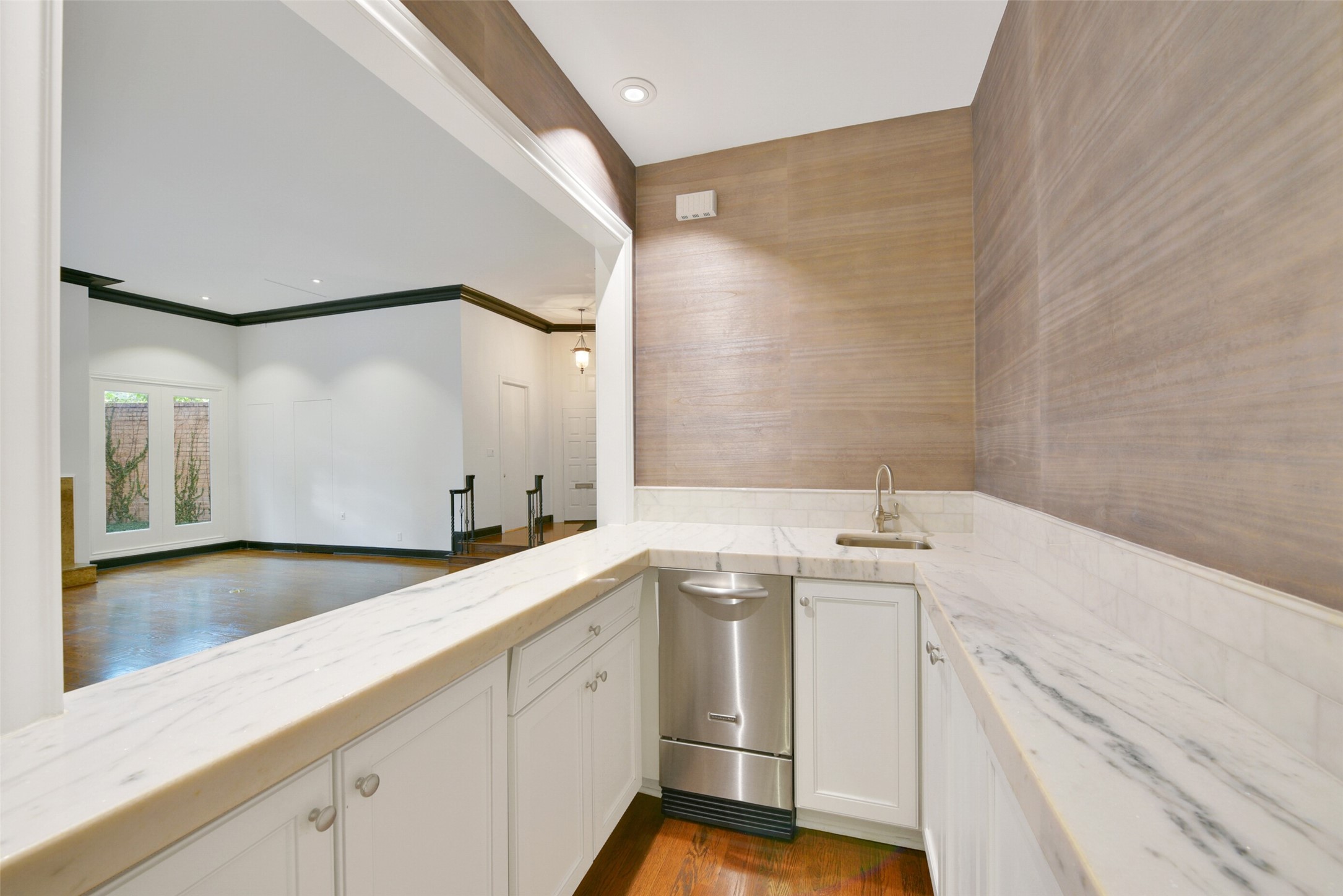Carrara marble and subway tiles accent the large wet bar with ice maker.