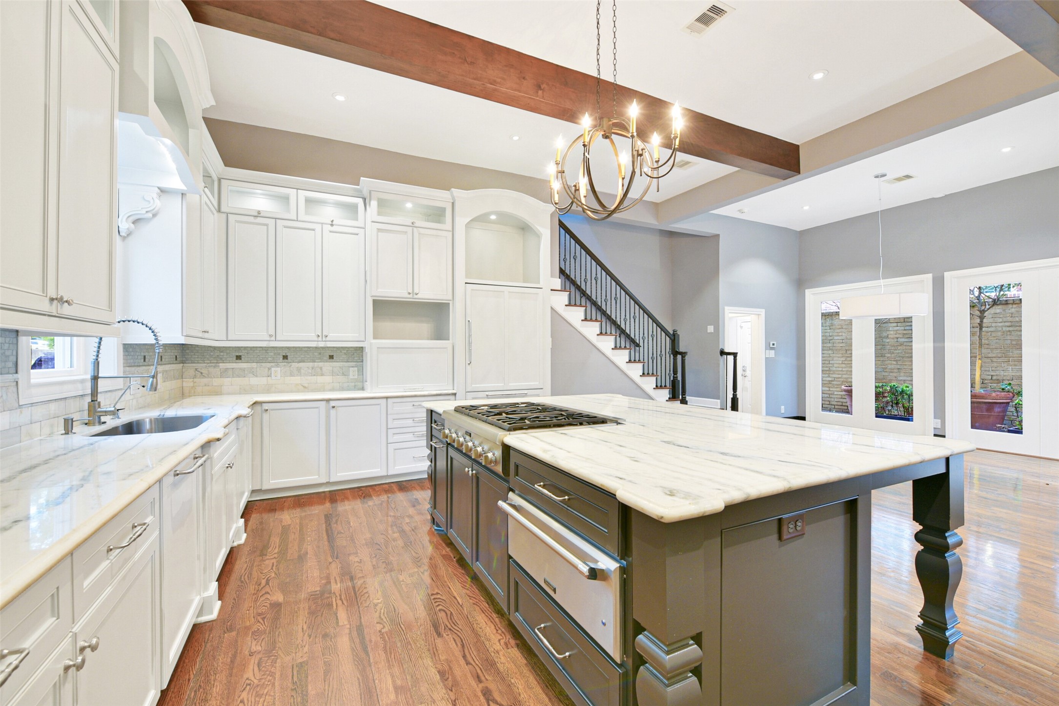 Carrara marble counter-tops and backsplash highlight the cabinetry and kitchen island. Upper cabinets are lighted for display. The island can seat four to five people comfortably. There are two staircases originating from the kitchen and morning room lead to the second floor, where a sense of privacy envelops the primary retreat.