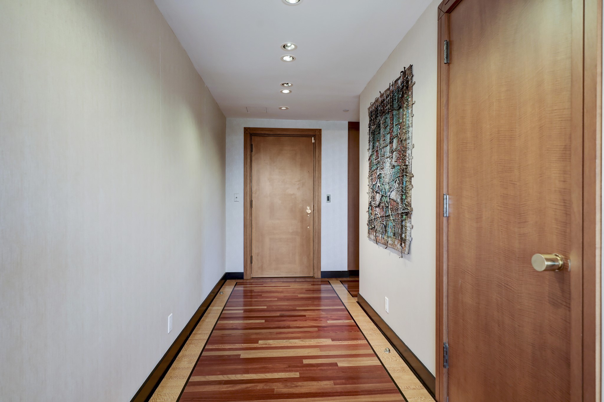 Entry has gleaming cherry hardwood floors.  Note the excellent wood craftsmanship in the inlaid design in the front door.