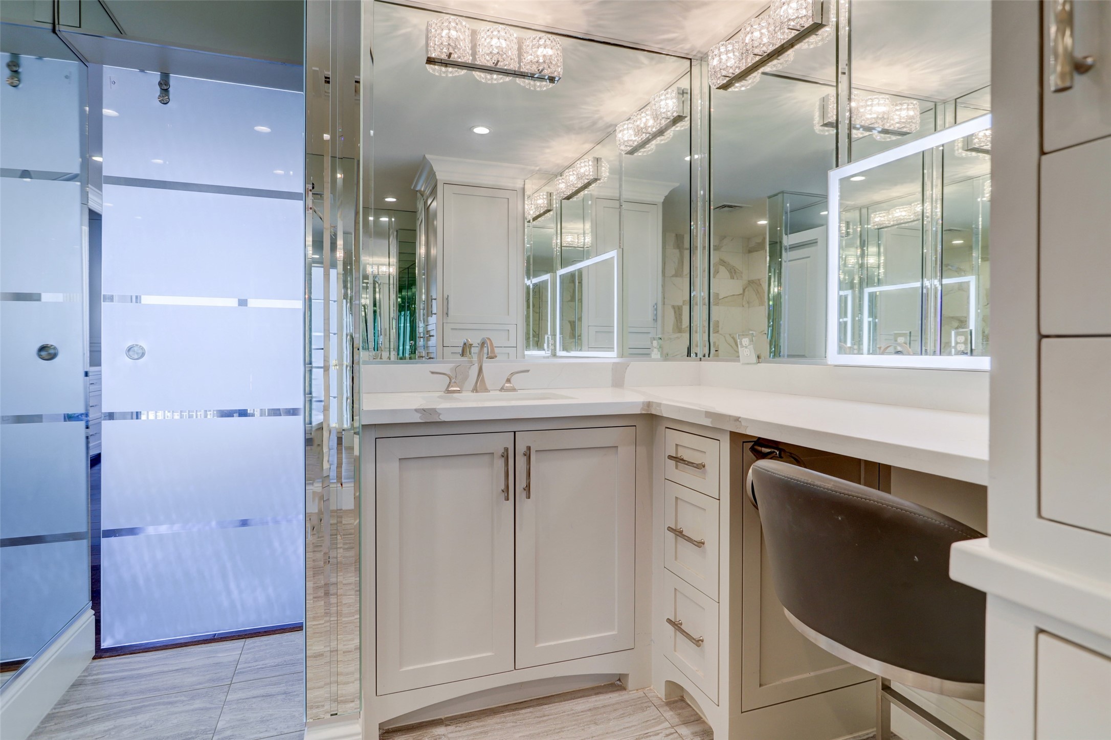 The lighted mirror is a nice addition to the vanity area with quartz counters and brushed nickel hardware.