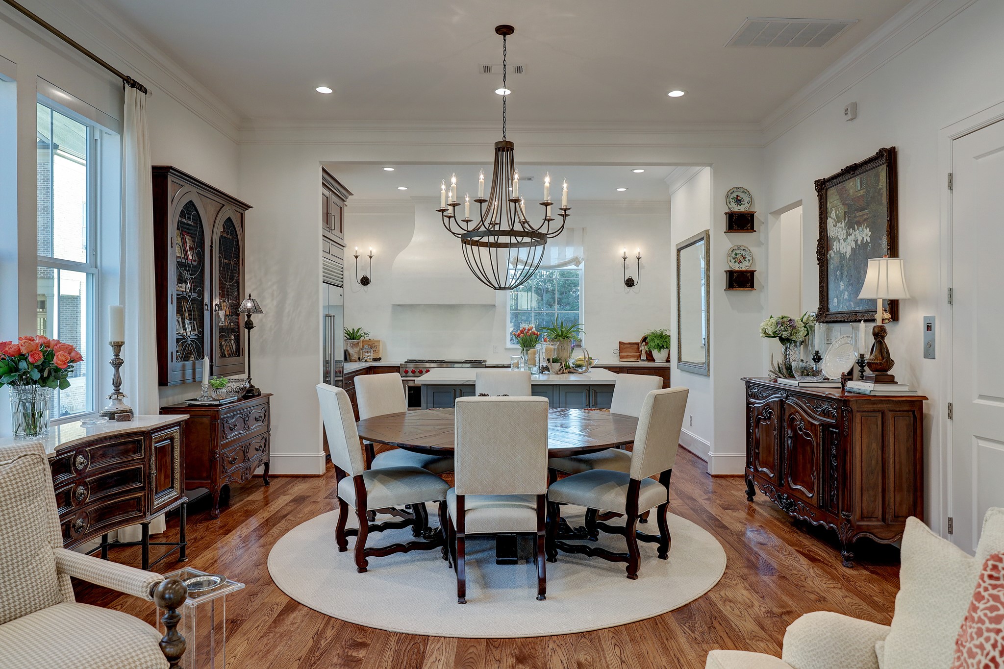 The formal dining room features custom drapes and motorized shades, sophisticated recessed lighting, Julia Neill chandelier, and double crown molding.