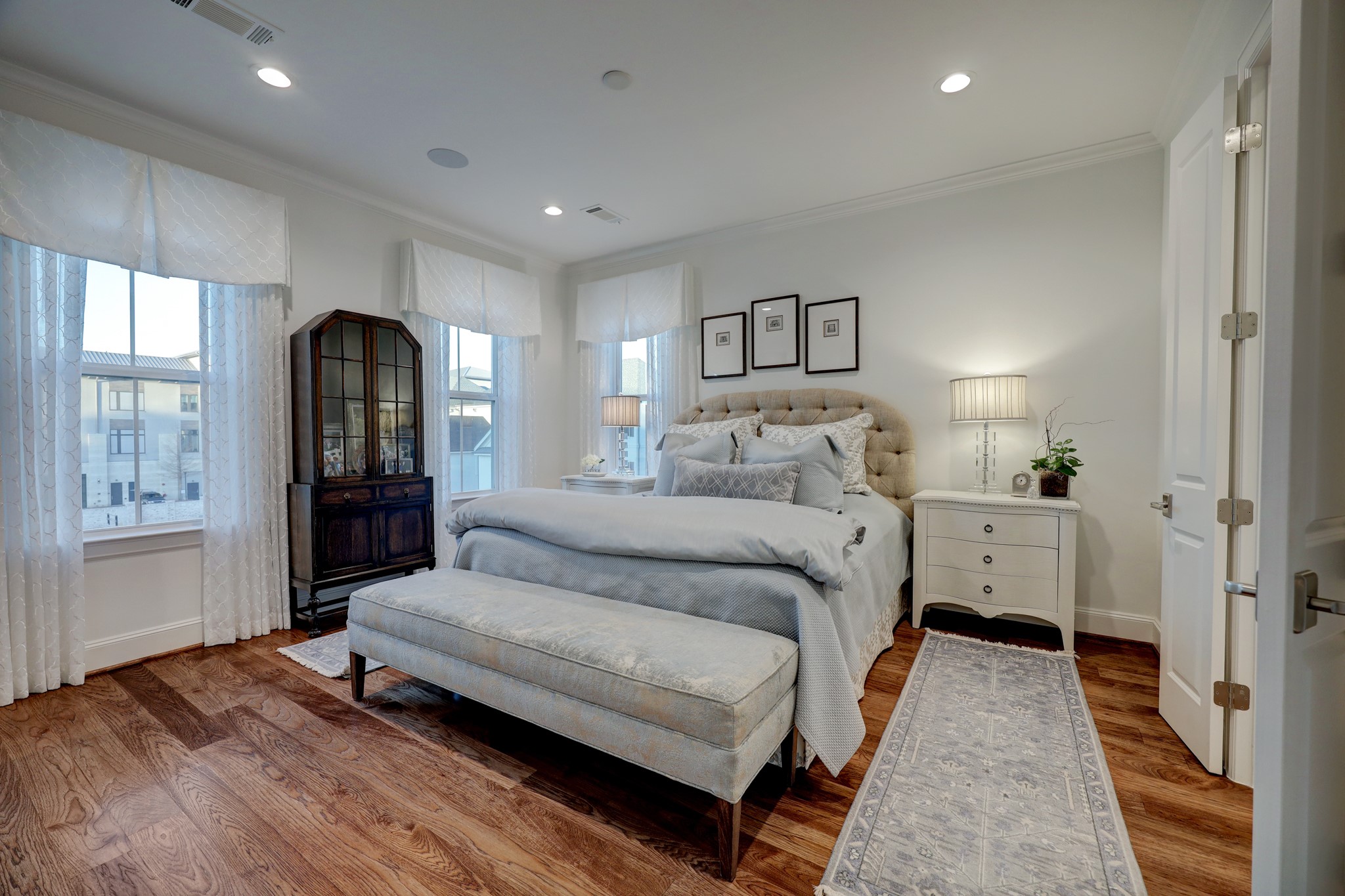 Restore and relax in your primary retreat featuring abundant natural light, hickory wood flooring, recessed lighting, and two expansive walk-in closets with custom built-in drawers and shelving.