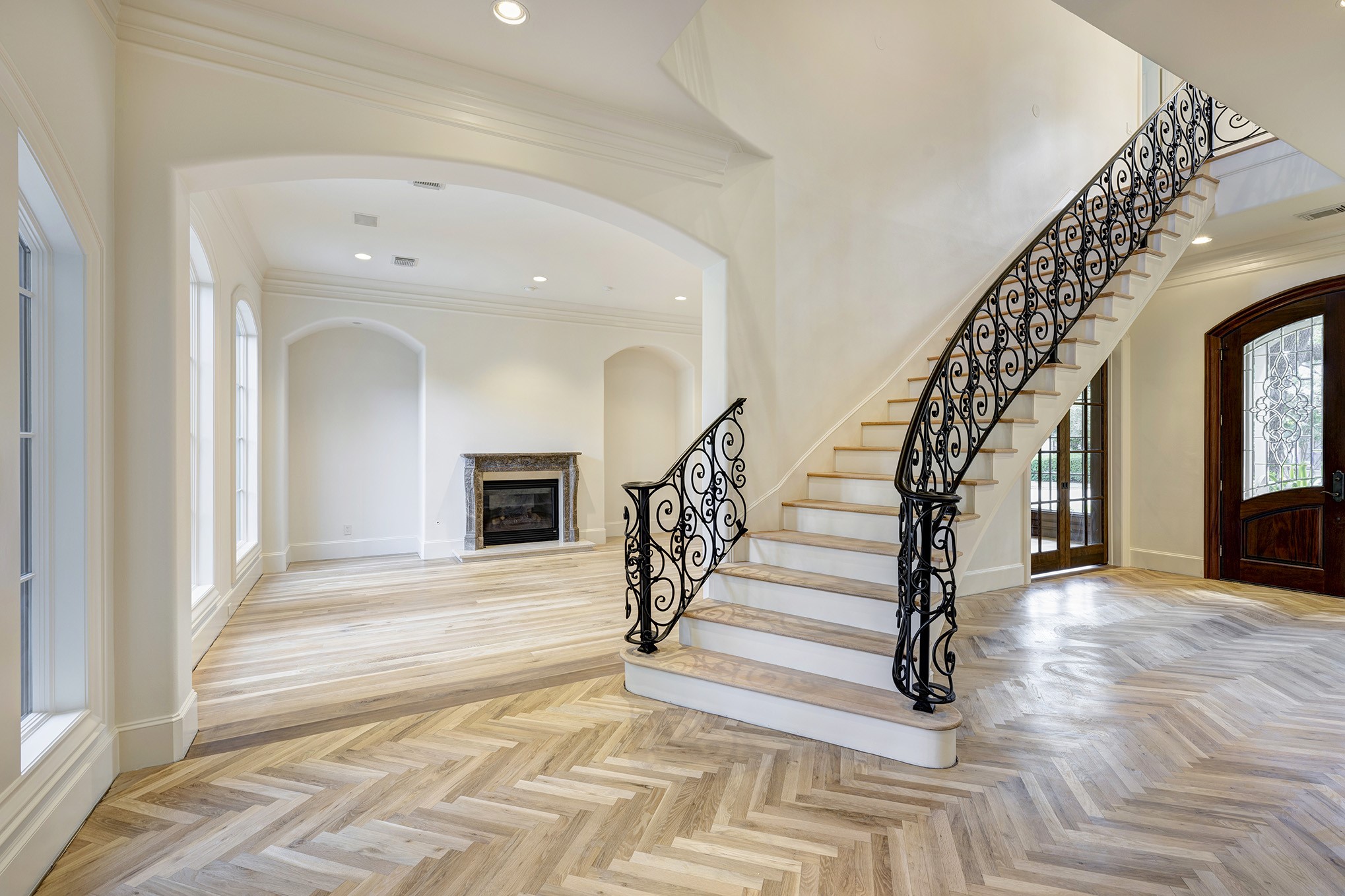 Grand entryway features sweeping staircase and high ceilings.