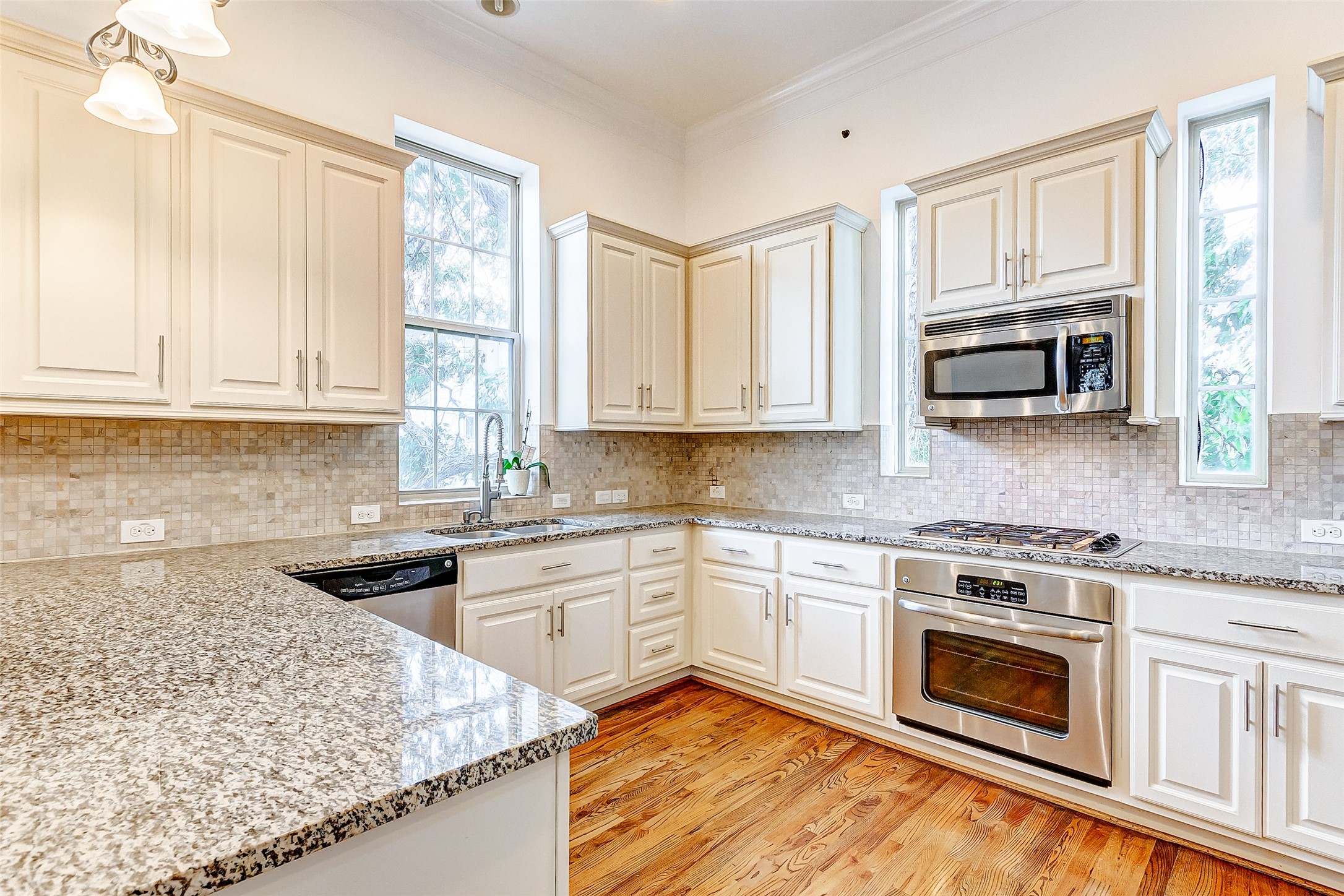 Welcome to your beautifully updated kitchen offering granite countertops paired with coordinating backsplash, stainless steel appliances, gorgeous wood flooring, and plentiful natural lighting!