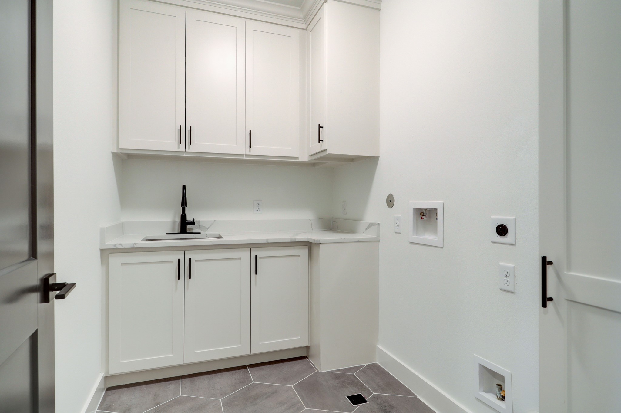 Utility room with sink and ample storage on second floor.