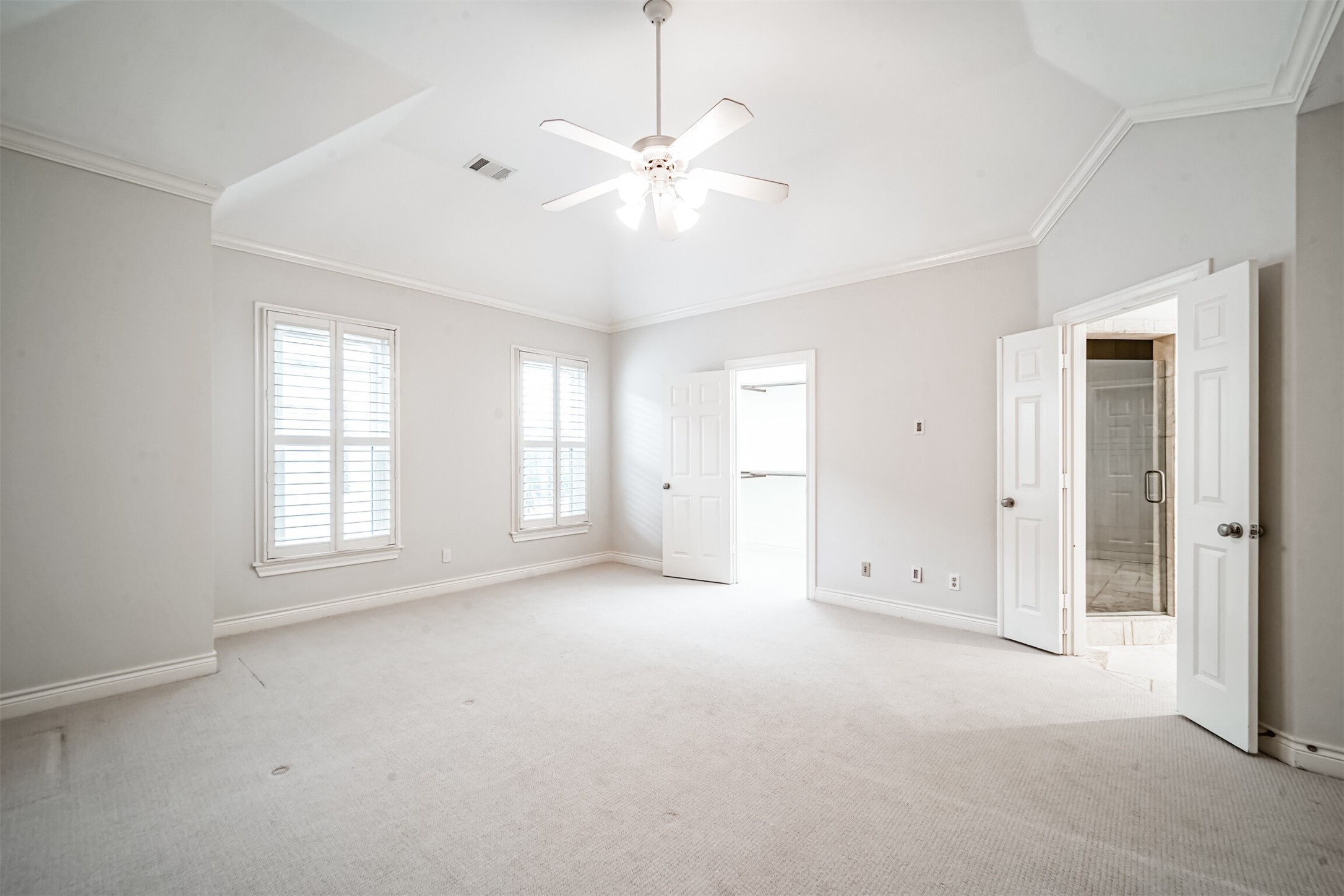 Beautiful light and bright Primary Suite with soaring ceilings, crown molding, and sitting area.