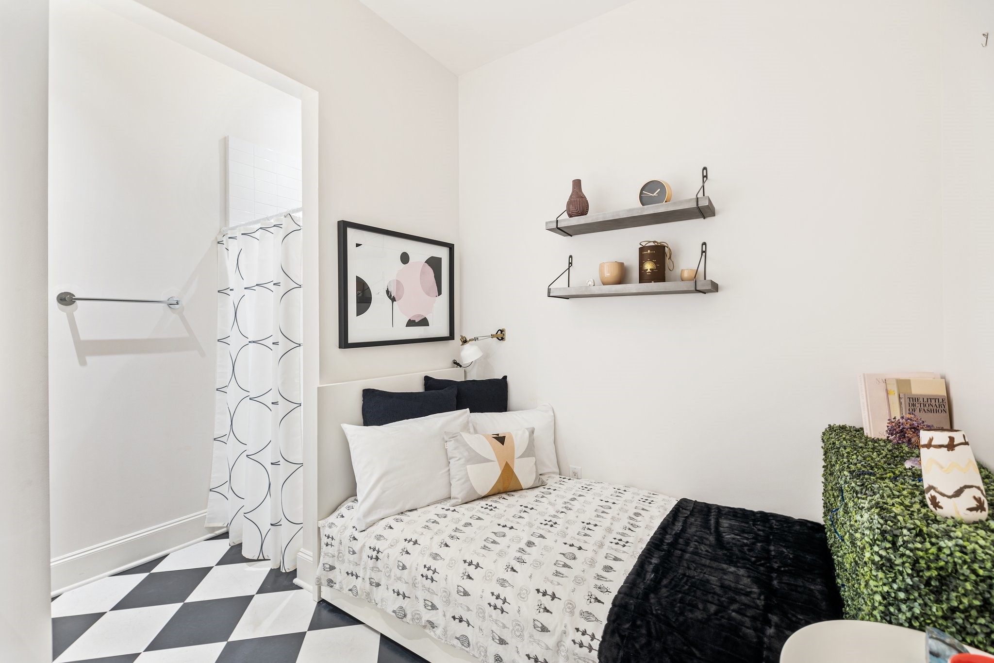 A welcoming 4th bedroom with modern decor, versatile as a guest suite or nanny's quarters. It boasts geometric flooring, sleek shelving, and artistic wall accents.