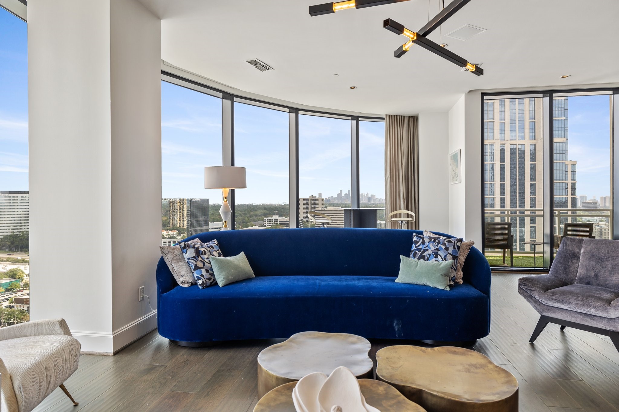 An interior overlooking the cityscape with the Post Oak Hotel in the distance, complemented by a mix of neutral and vibrant tones on the walls and decor.