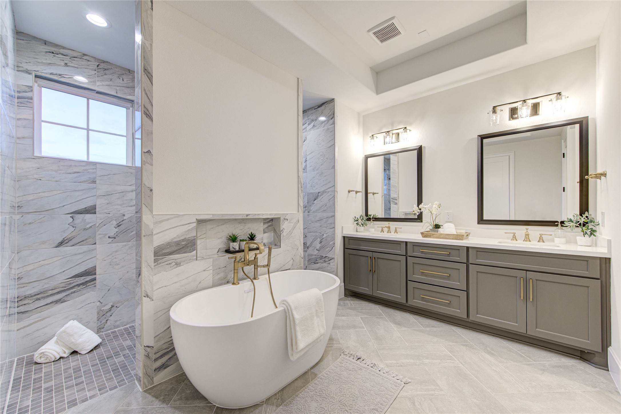 he spa-like ensuite bathroom boasts a dual-entry walk-in shower and a free-standing tub with gorgeous marble detailing.