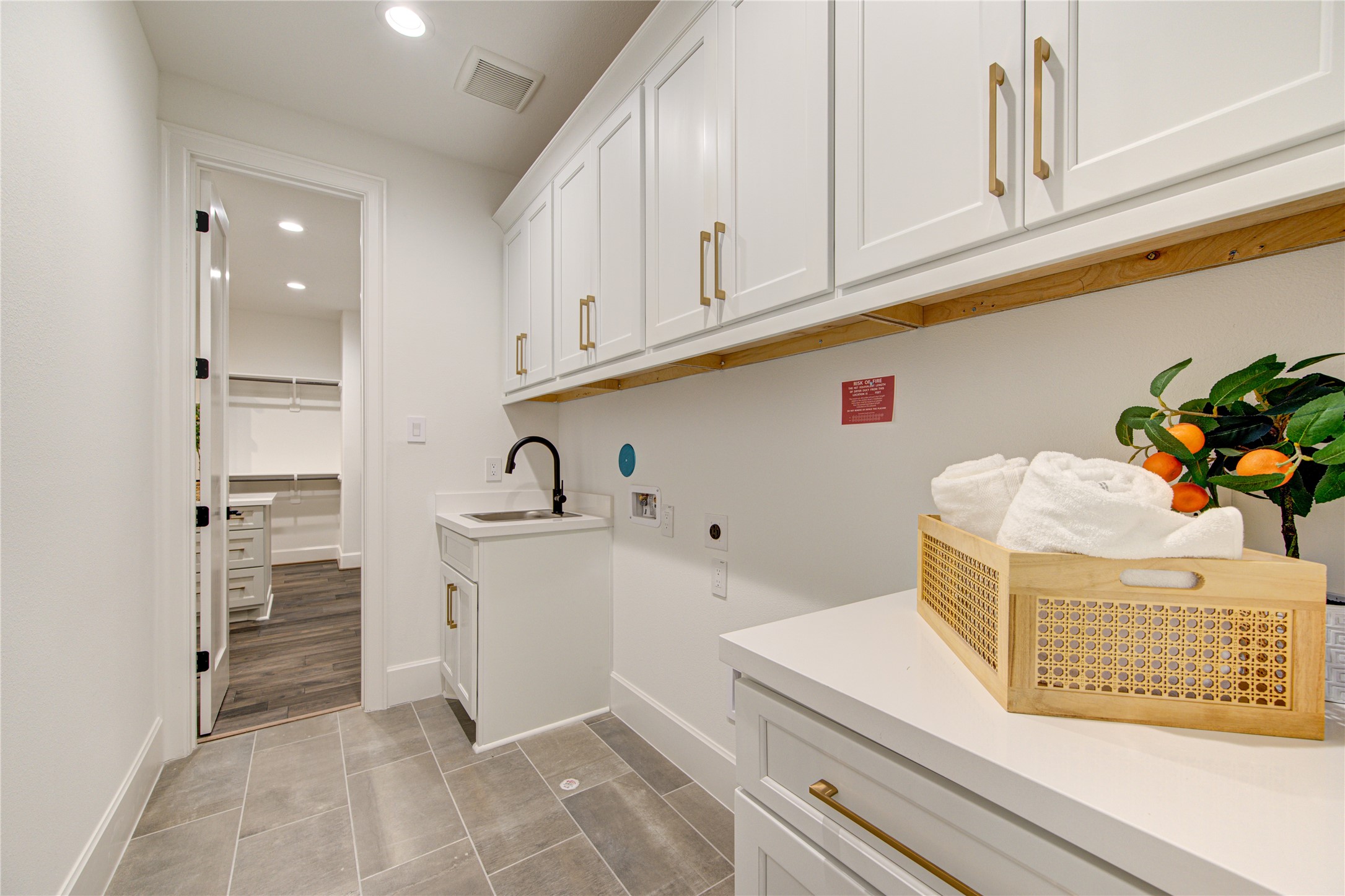 You may love doing your laundry again in this stylish laundry room on the second floor with tons of cabinets.