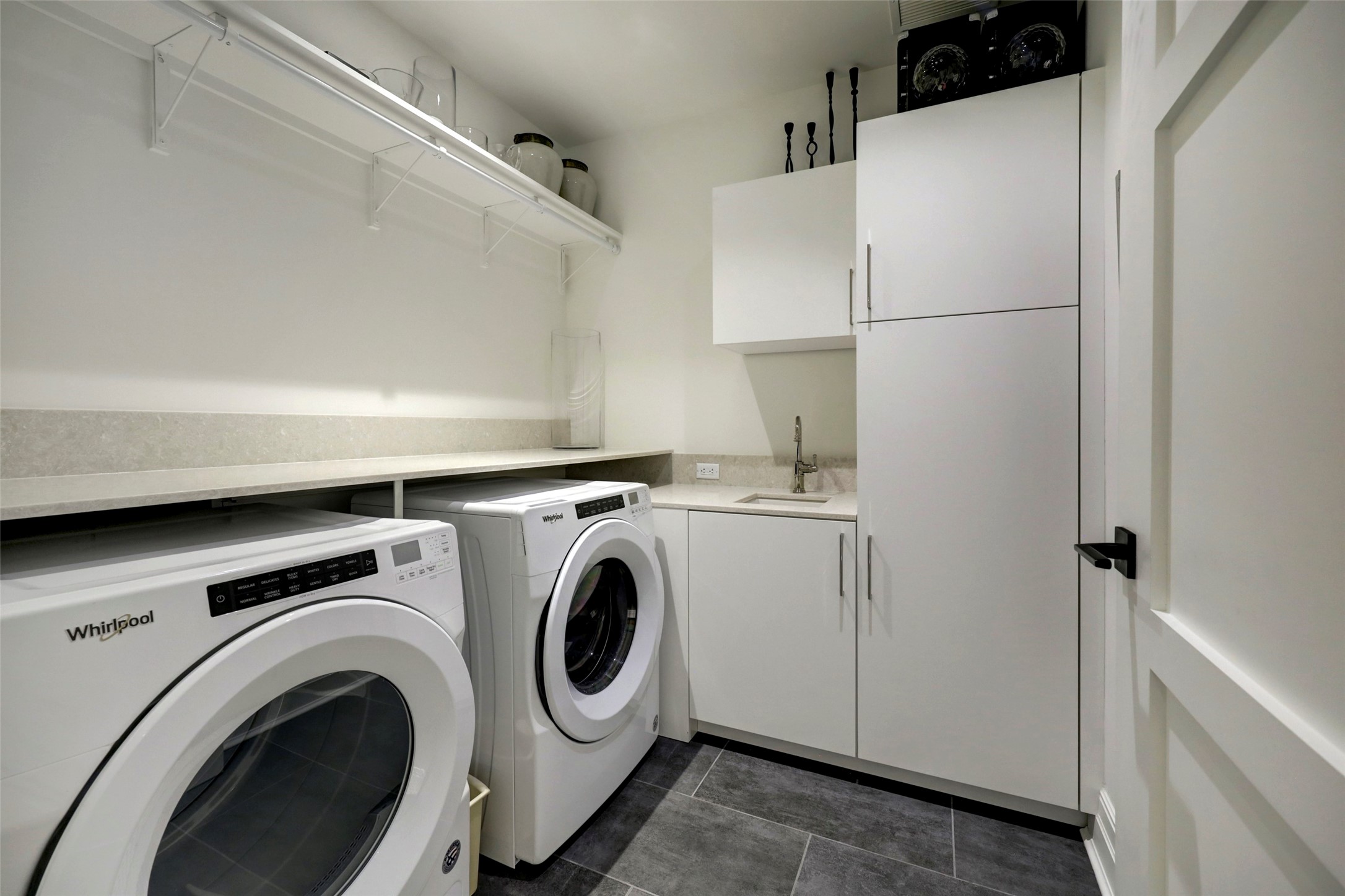 The very well-stocked Utility Room has tile floors, a sink and extra storage.