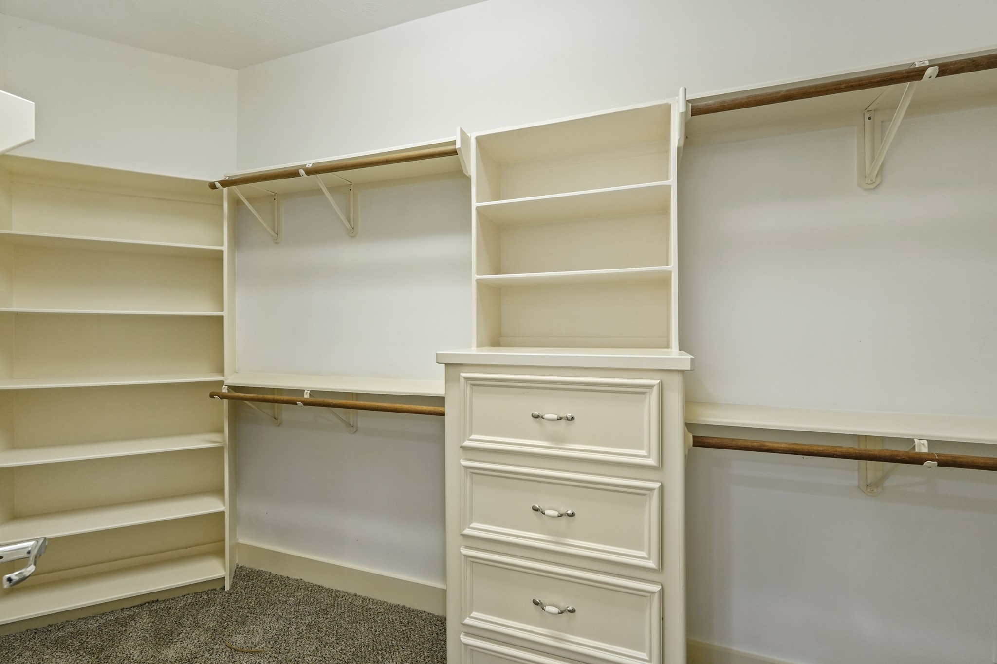Primary closet with built in shelves and chest