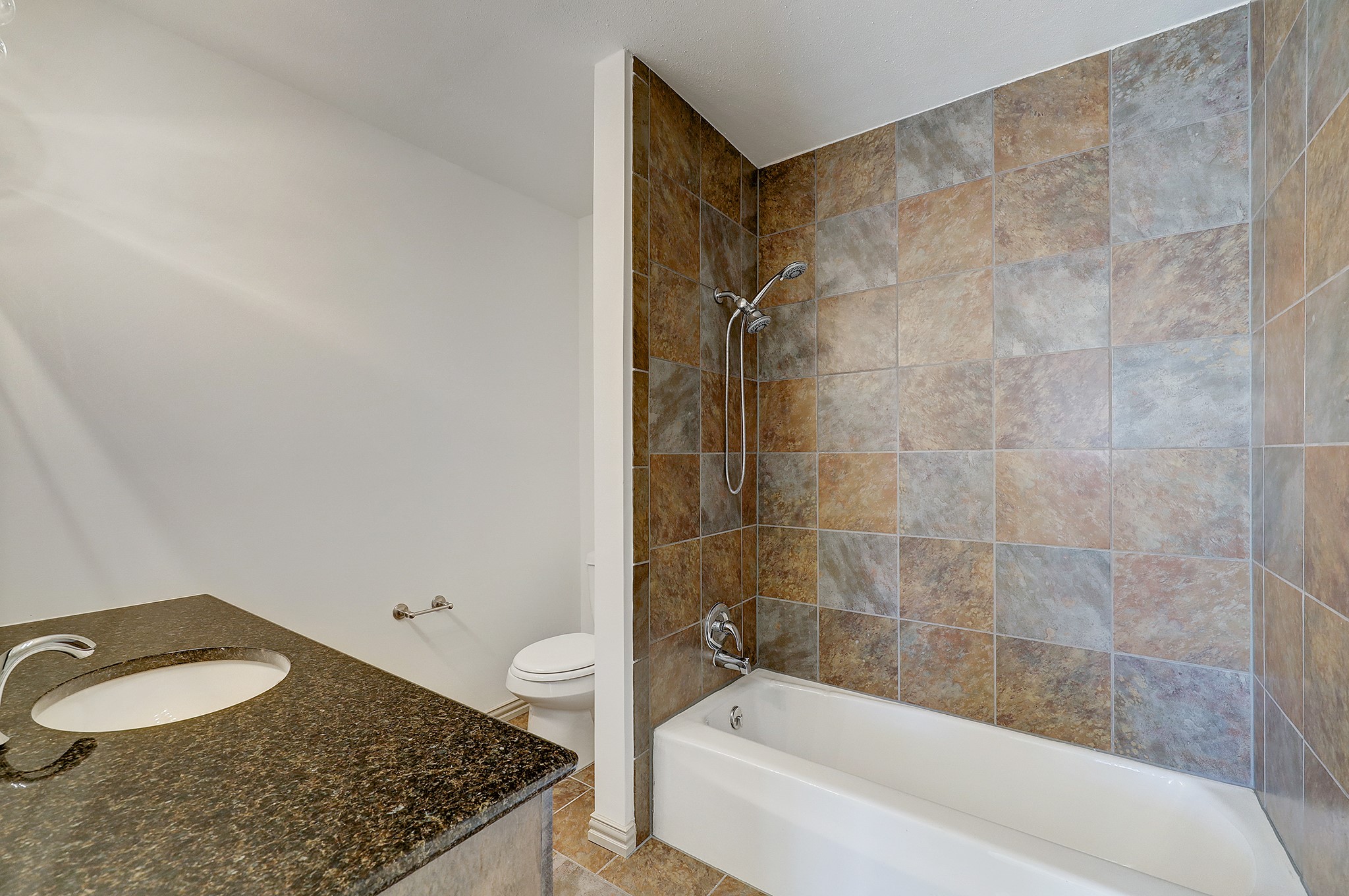 Nodding to its traditional charm, stoned tile extends throughout the tub/shower area. Granite countertops, with an under-mount sink and chrome plumbing fixtures, complete the space.