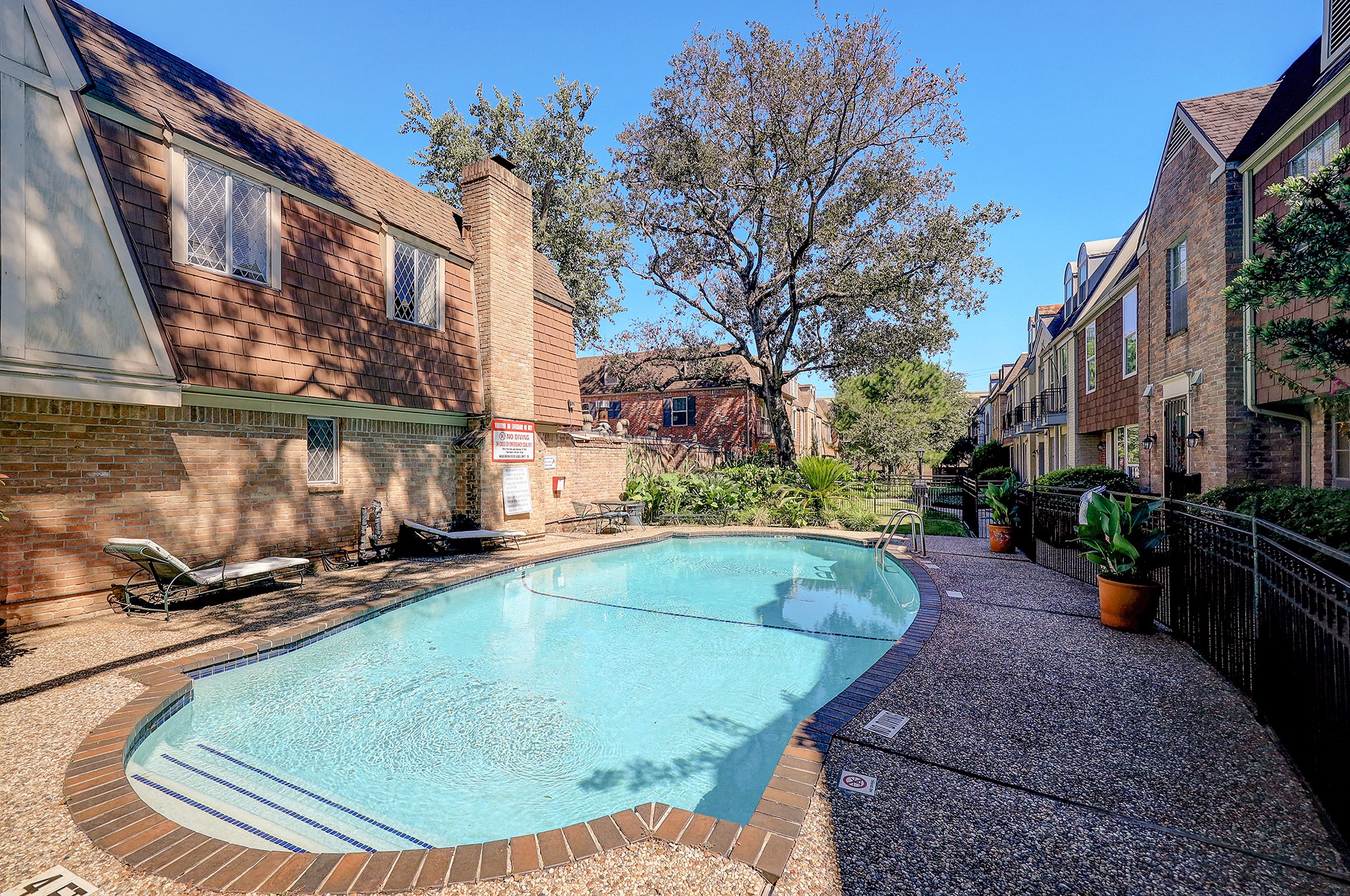 A community pool is surrounded by a manicured landscape and offers the perfect place to relax.