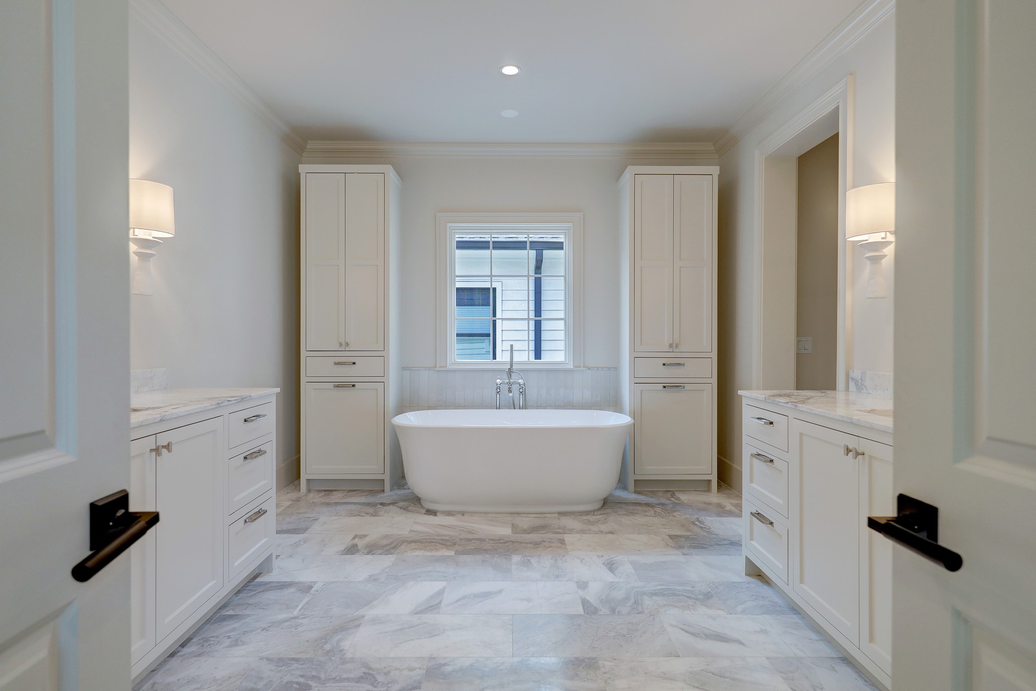 Unwind in the owner's spa-like bathroom offering two vanity areas with designer lighting, soaking tub, Sienna Sunset marble 12” x 24” on floor, Michelangelo Arabescato countertops & separate walk-in shower and walk-in closet.