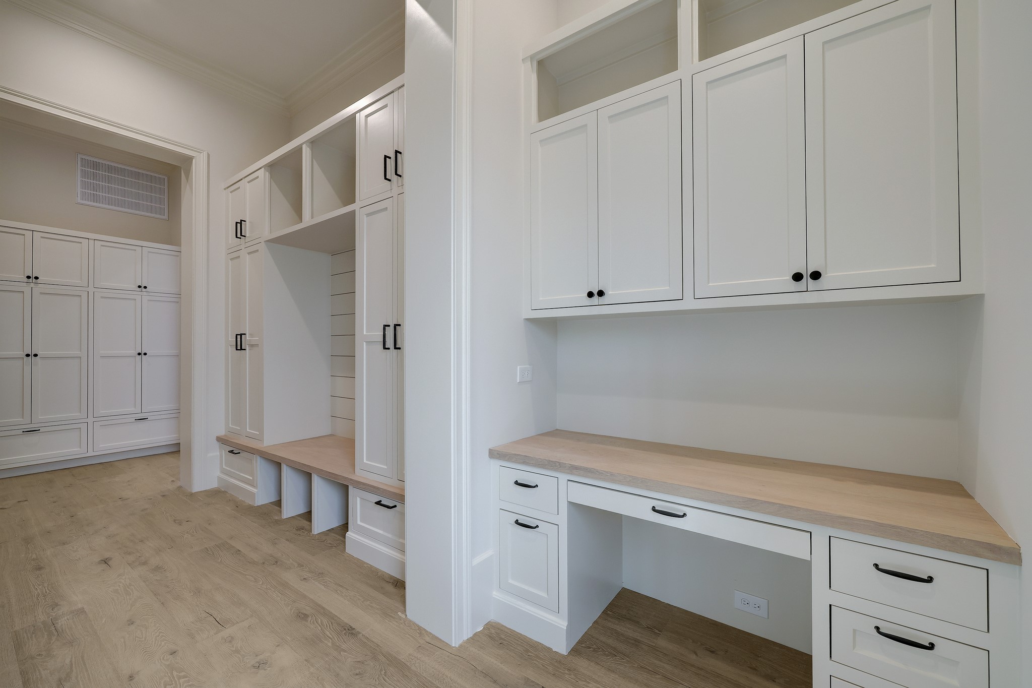 When you arrive from the two-car attached garage, you're welcomed to this fabulous drop-off/ mud room space with built in desk, lockers, and storage.