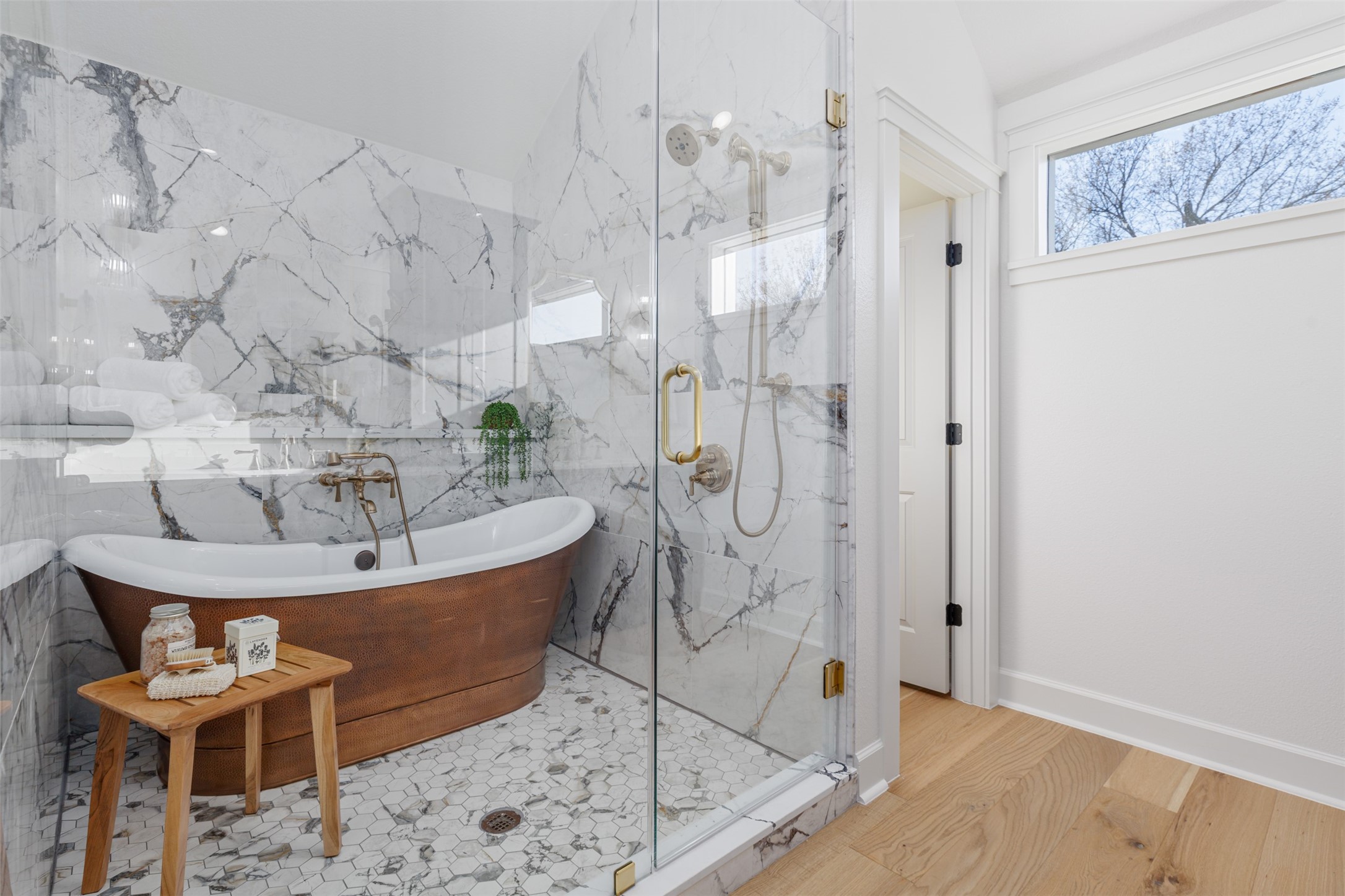 This beautiful fully geometrically tiled shower/tub combo with modern sliding glass doors, champagne brass hardware, double sinks and quartz surface areas and statement color cabinets provide a most elegant ensuite to the guest room and also cleverly serves as the downstairs bathroom for the house by separate access.