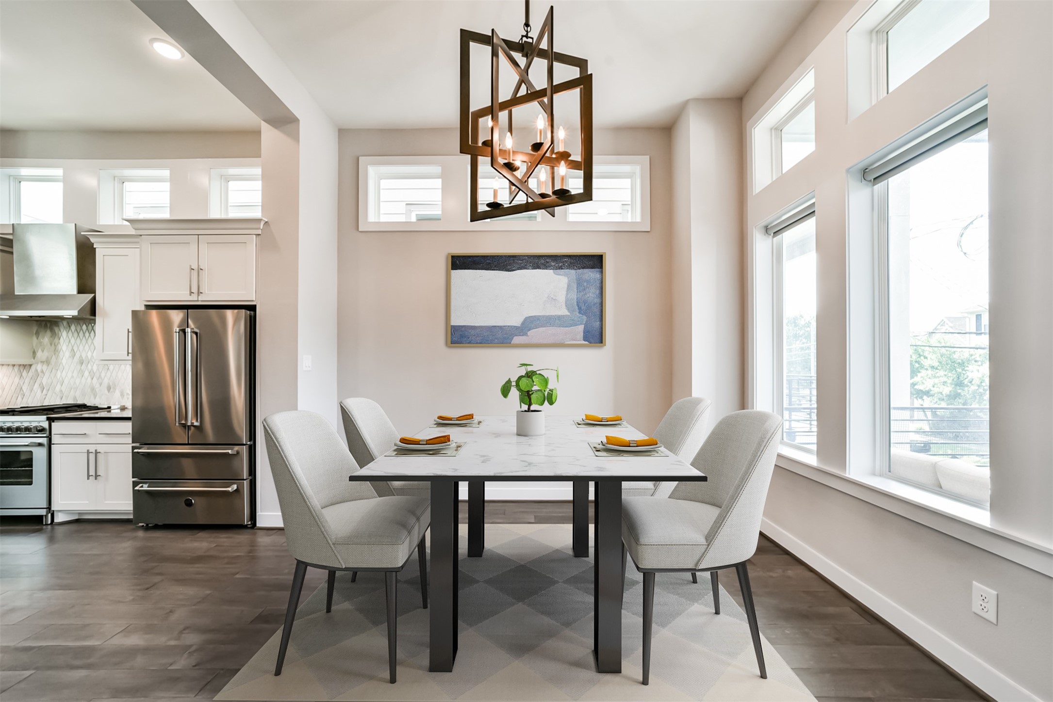 Light and bright formal dining room with accent light fixture opens to the kitchen and living room. Virtually staged.